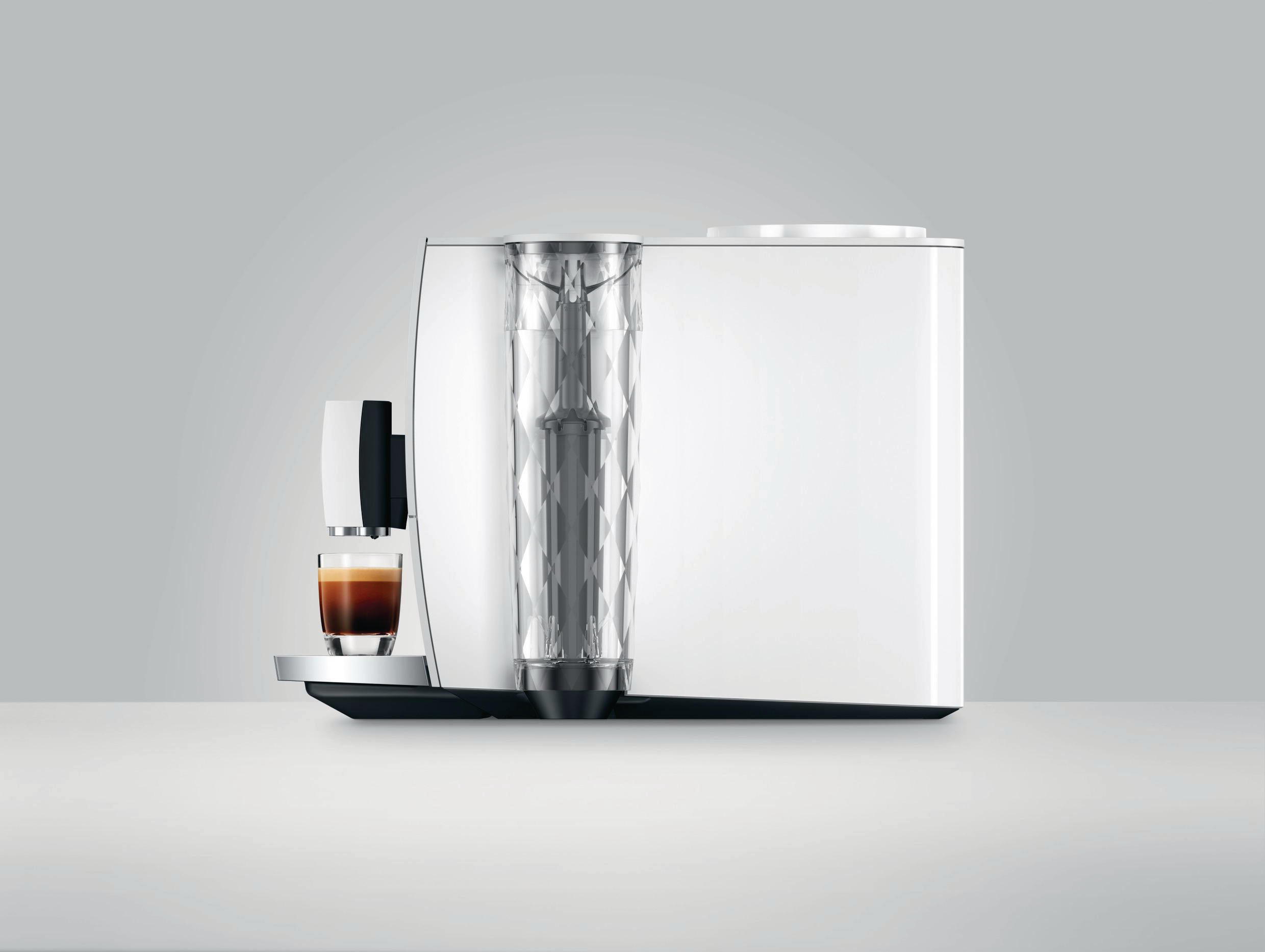 Weiße Jura-Kaffeemaschine mit einem Glas Espresso. Transparenter Wasserbehälter. Weißer Hintergrund.
