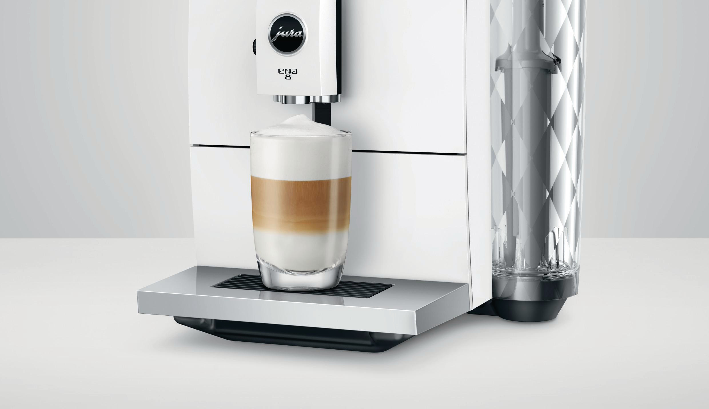 Kaffeemaschine mit einem Glas Latte, weißer Hintergrund.