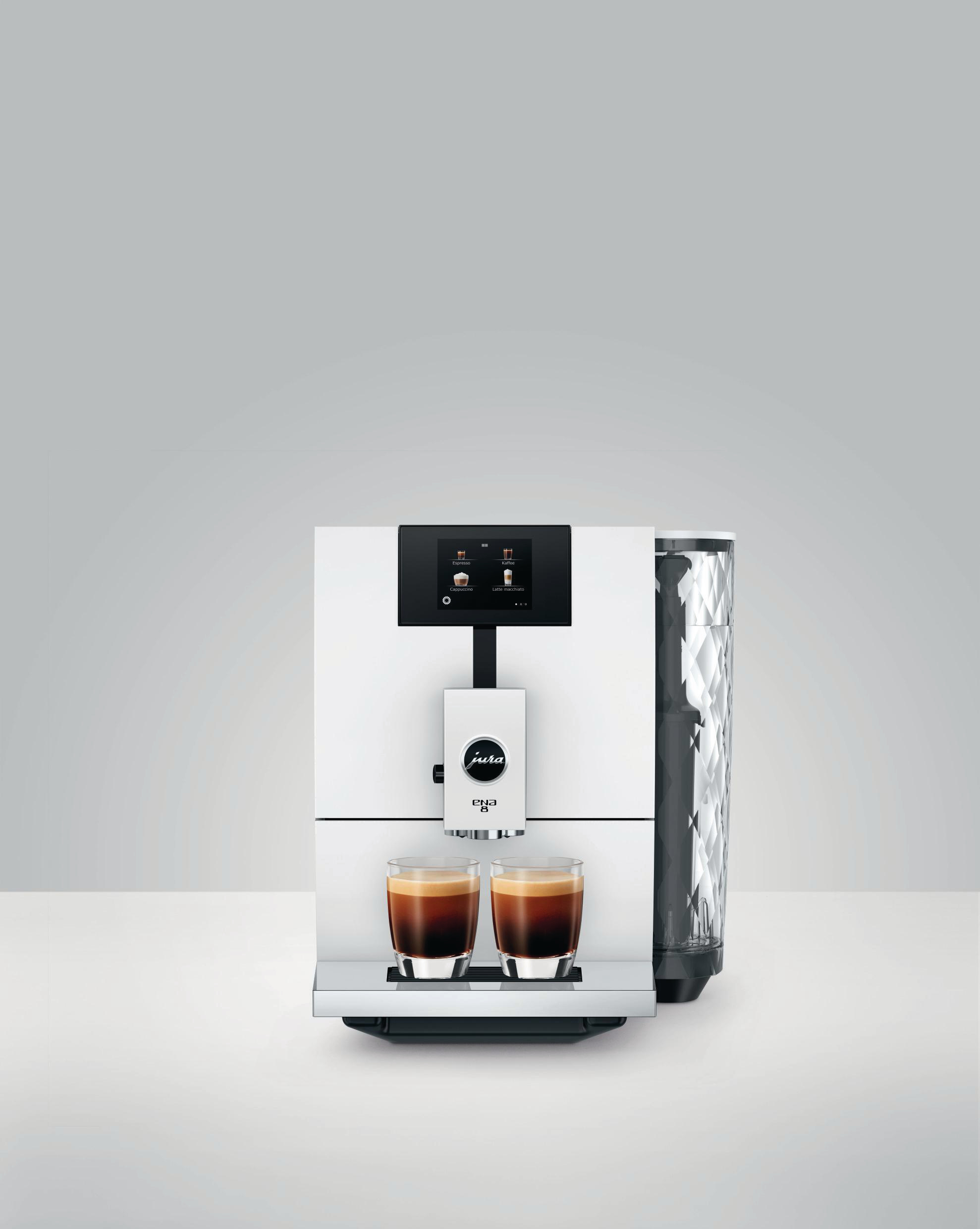 Weiße Jura ENA 8 Kaffeemaschine mit zwei Espressotassen. Grauer Hintergrund.