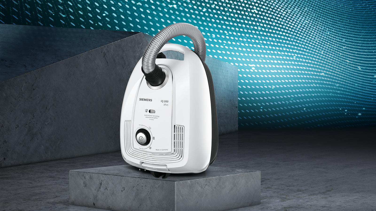 Weißer Siemens Staubsauger auf einer Plattform, vor blauem Hintergrund.