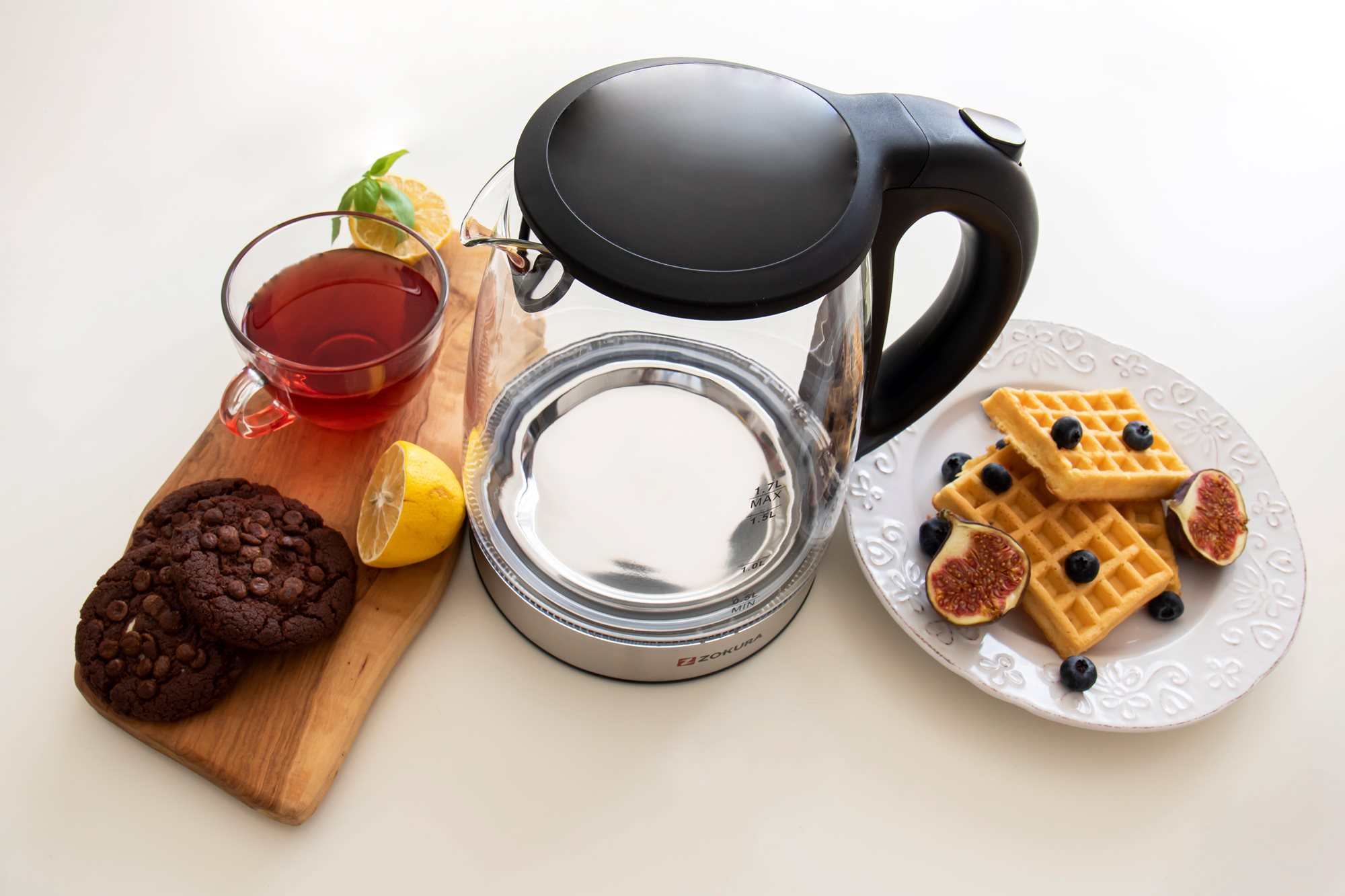 Teáskanna kiegészítőkkel, mint gofri, keksz, citrom és tea.