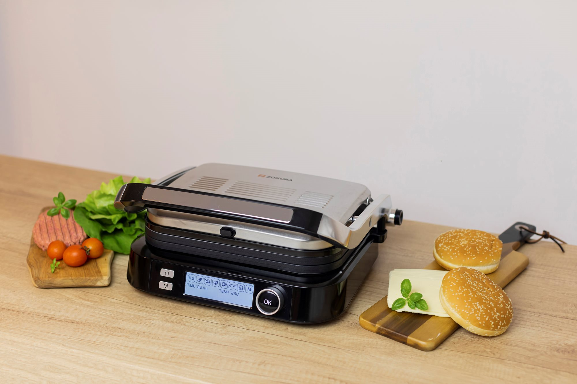 Grill étellel, hamburger hozzávalókkal és vágódeszkákkal az asztalon.