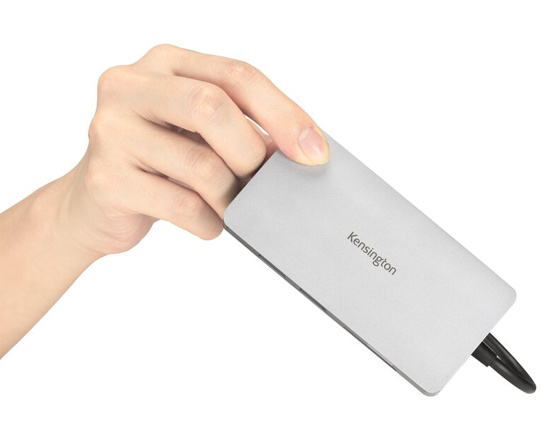 Egy kéz egy Kensington USB hubot tart, fekete kábellel.
