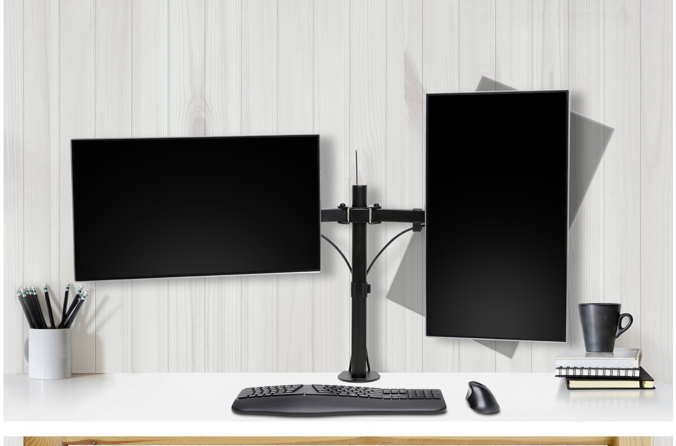 Kettős monitor beállítás. Két fekete monitor egy íróasztalon. Íróasztal ceruzákkal.