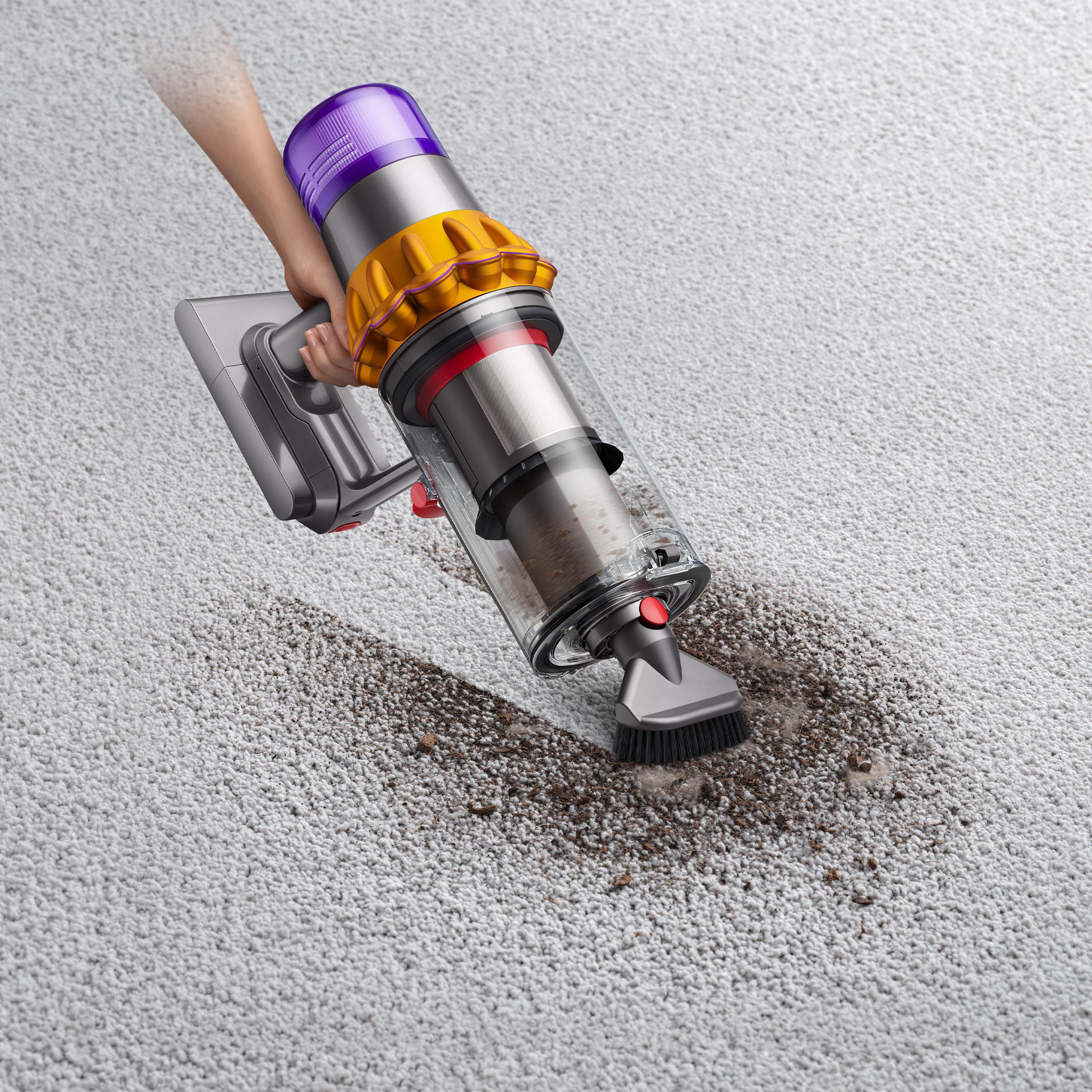 Person benutzt einen Dyson-Staubsauger auf Teppich.