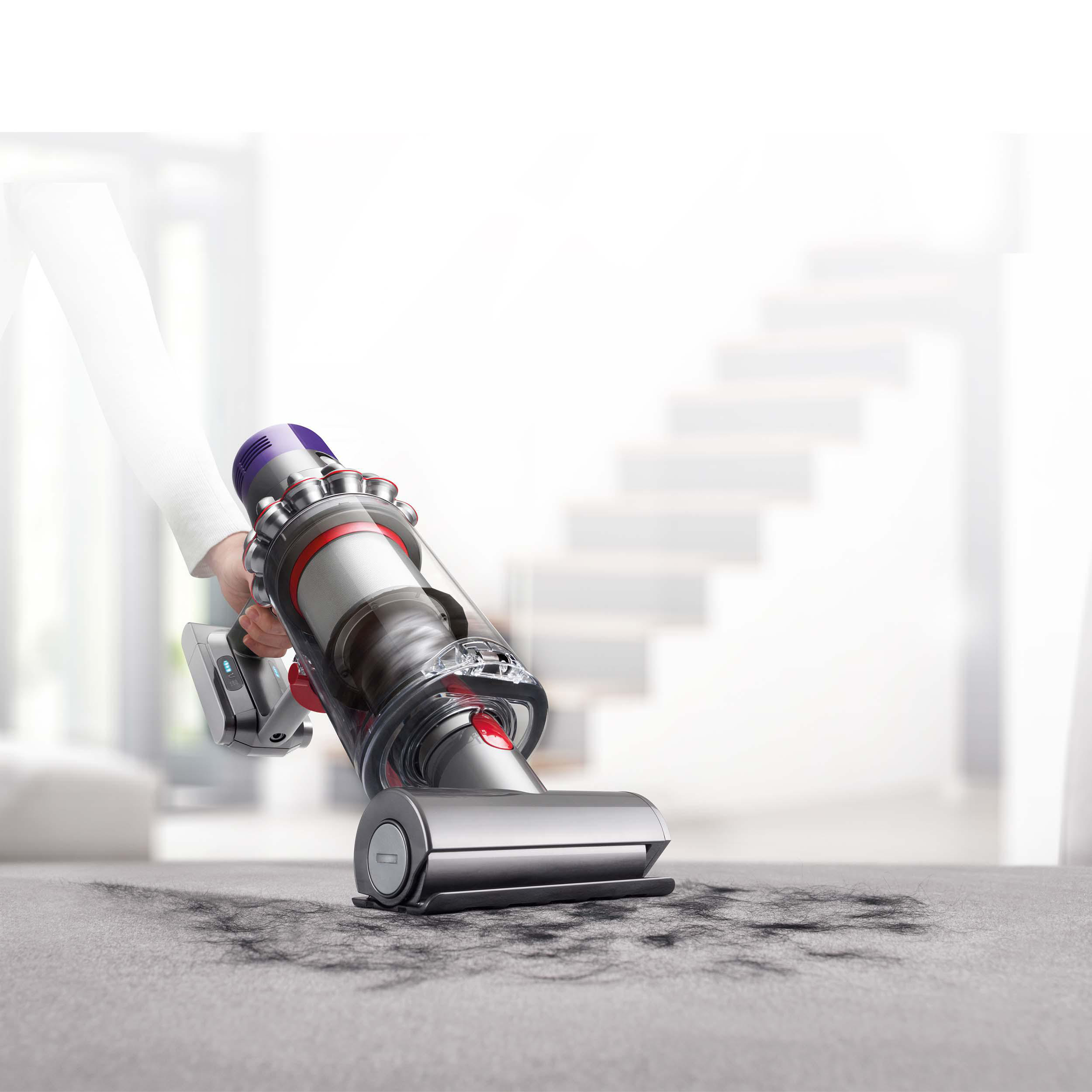 Ein Dyson-Staubsauger reinigt einen Teppich.