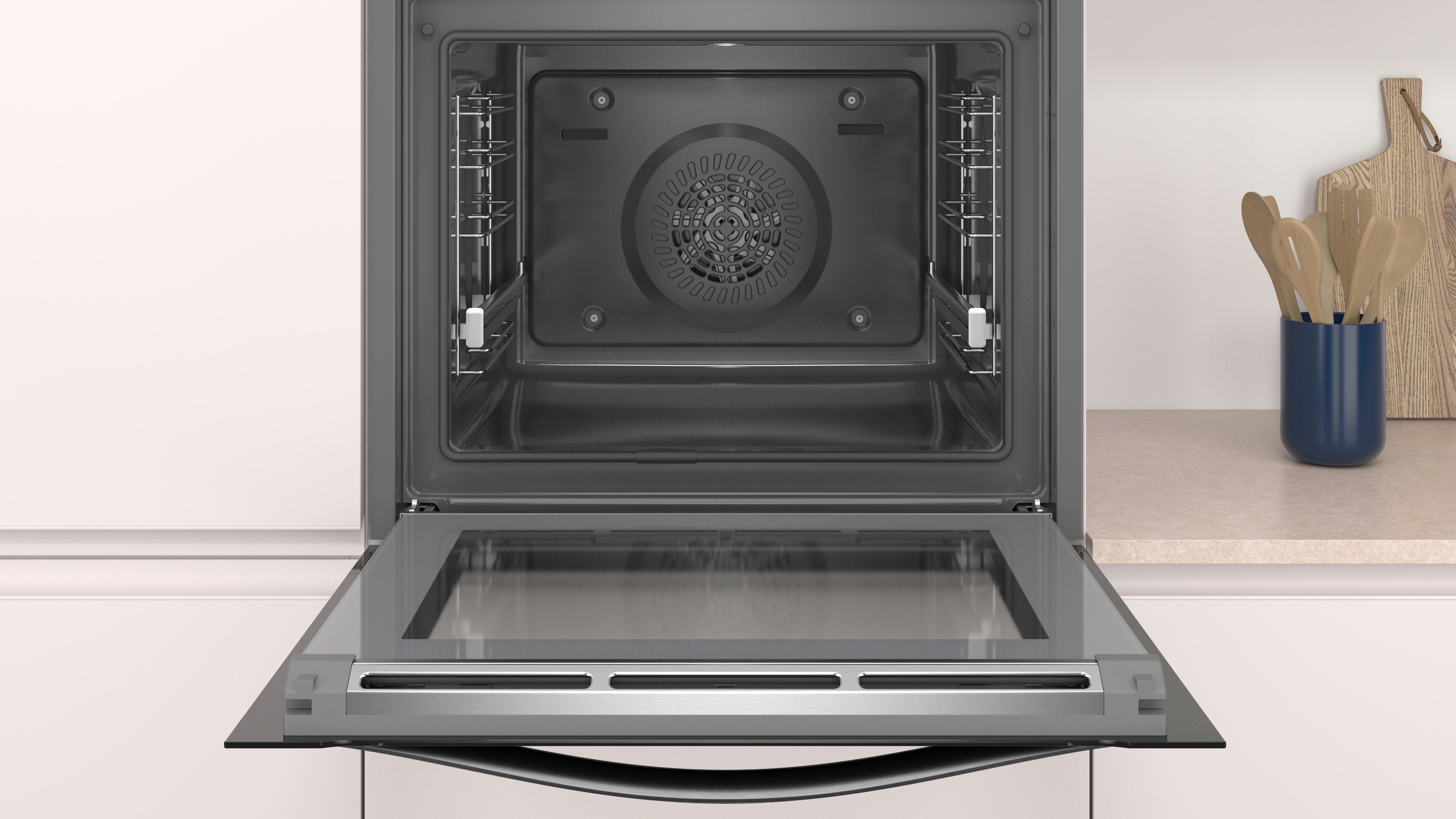 Un horno abierto con puerta de cristal. Dentro, hay rejillas metálicas. El horno es blanco y está en una cocina.