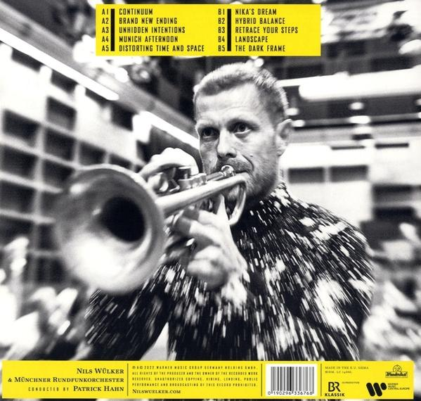 Ein Mann spielt Trompete, im Hintergrund ein Musikalbumcover mit einer Titelliste.