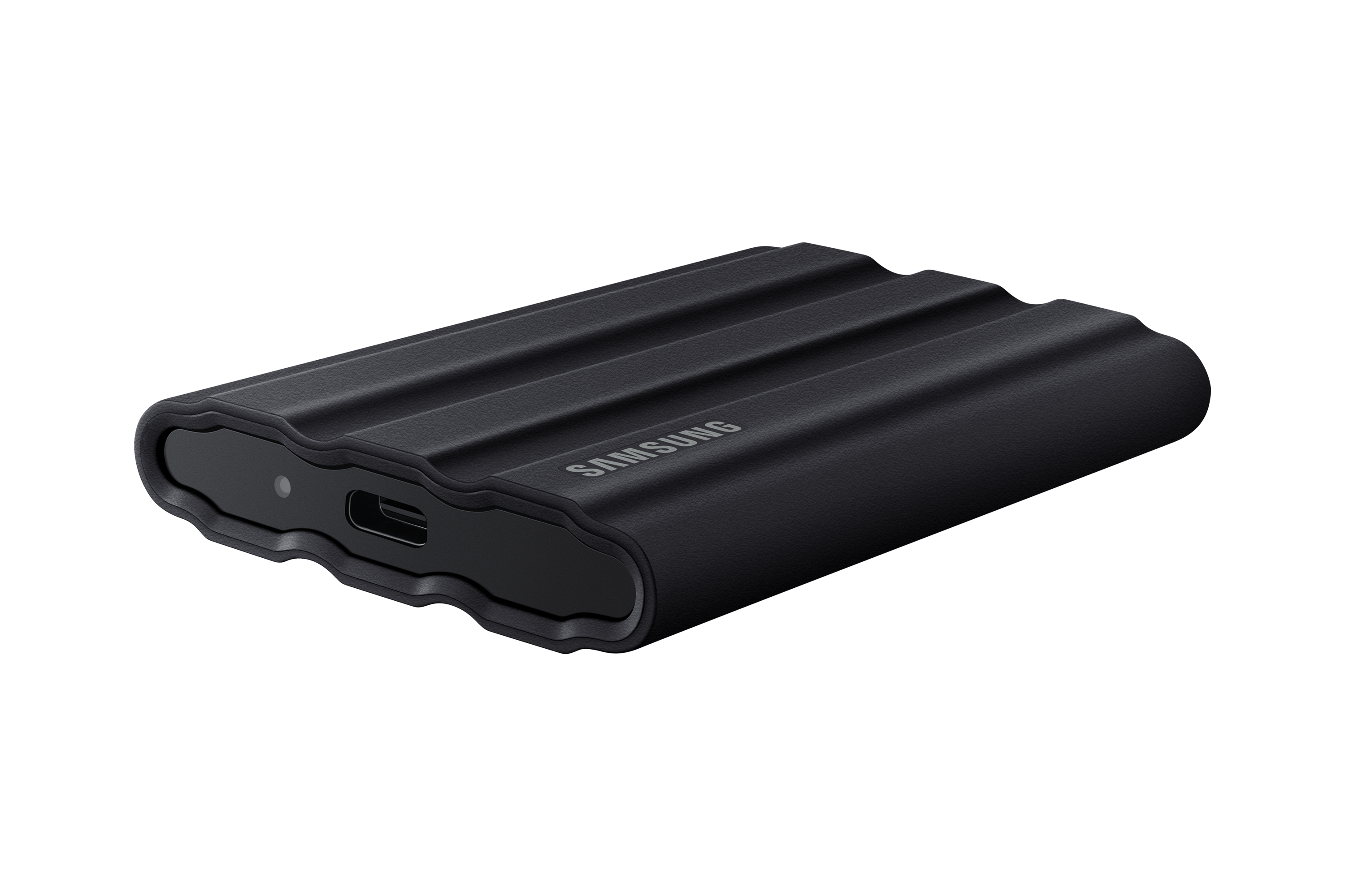 Zwarte, geribbelde Samsung externe harde schijf op zwart oppervlak. Beschikt over een USB-C-poort.