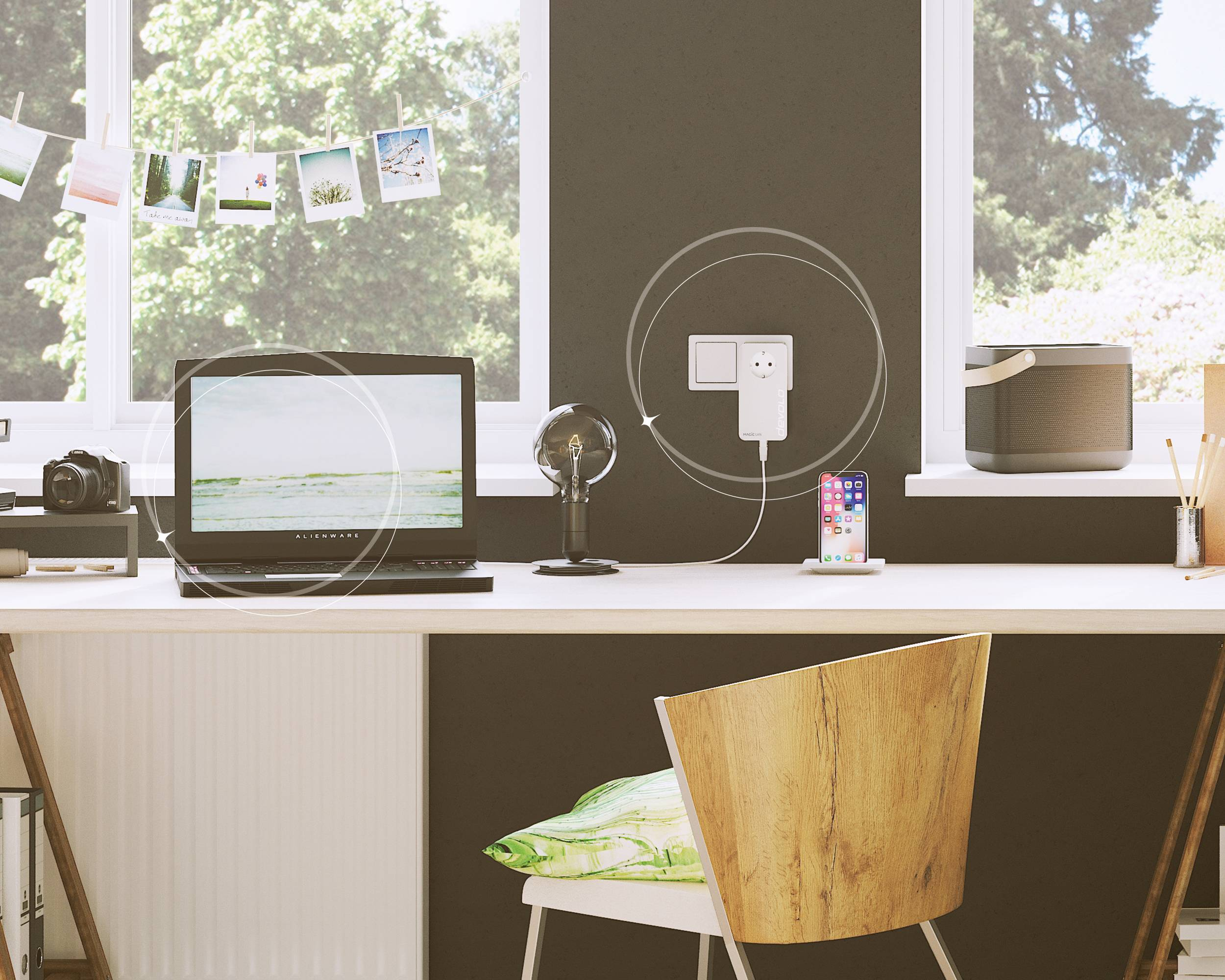 Ein Schreibtisch mit Laptop, Telefon laden und einer Lampe in einem gut beleuchteten Raum.
