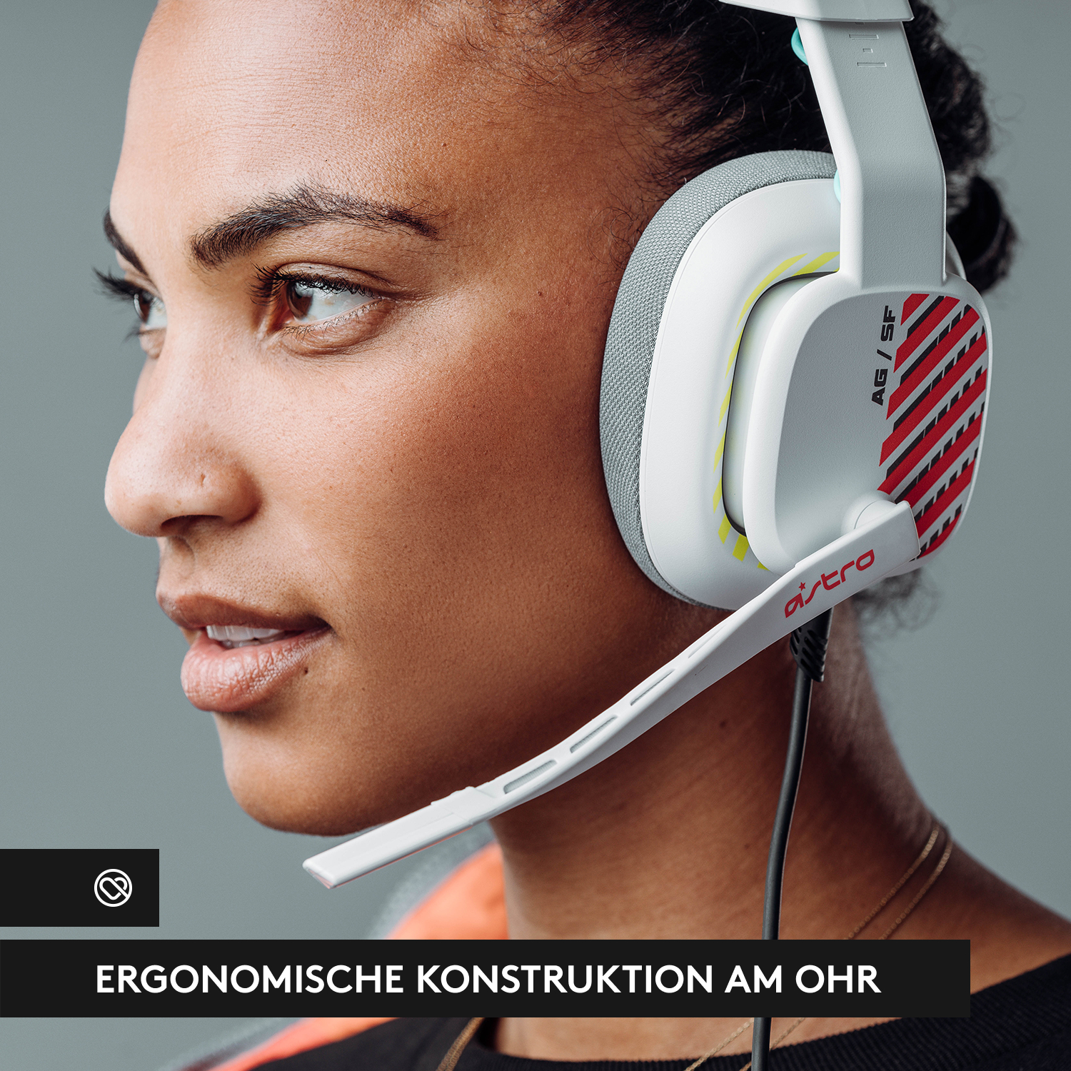 Frau mit weißem und grauem Gaming-Headset. Das Headset hat rote und gelbe Streifen.