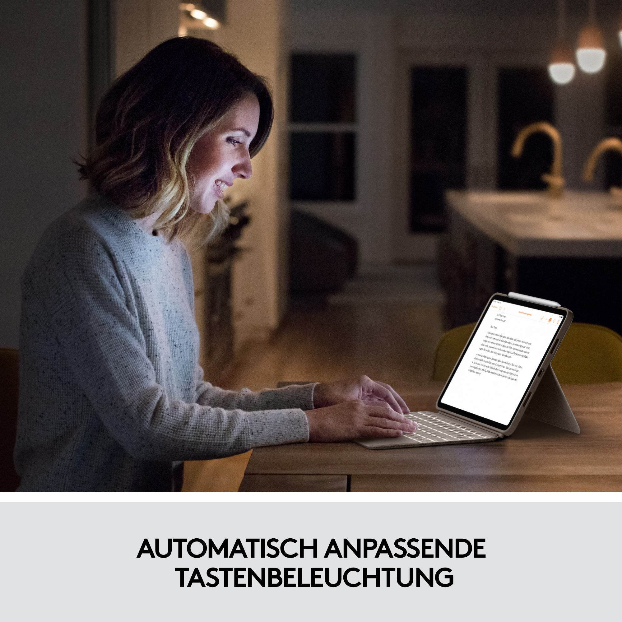 Eine Frau, die ein Tablet mit Tastatur an einem Holztisch unter warmem Licht benutzt.