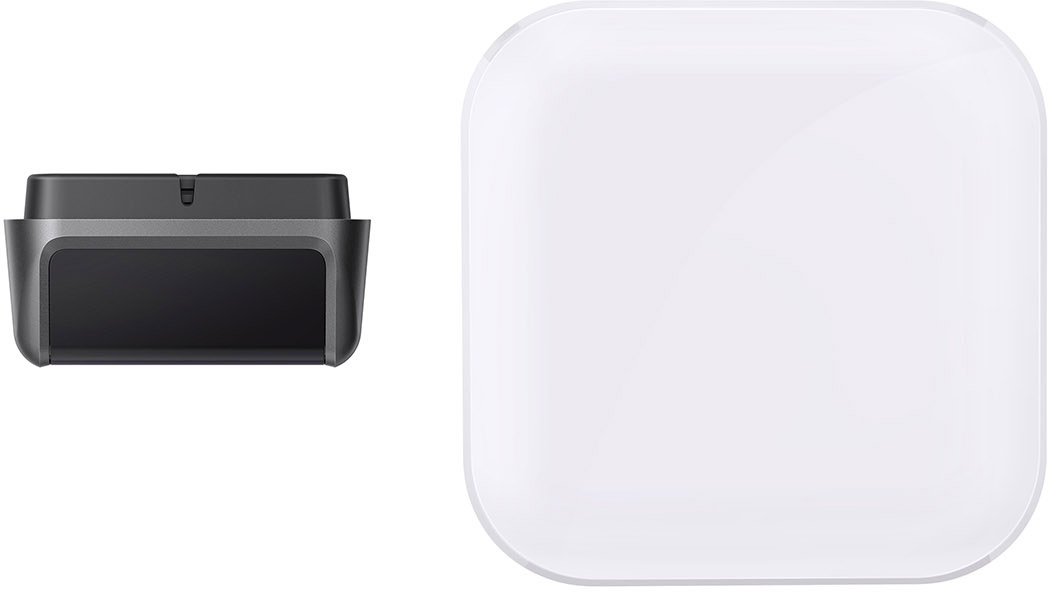 A black electronic device and a white square object with rounded corners are side by side.