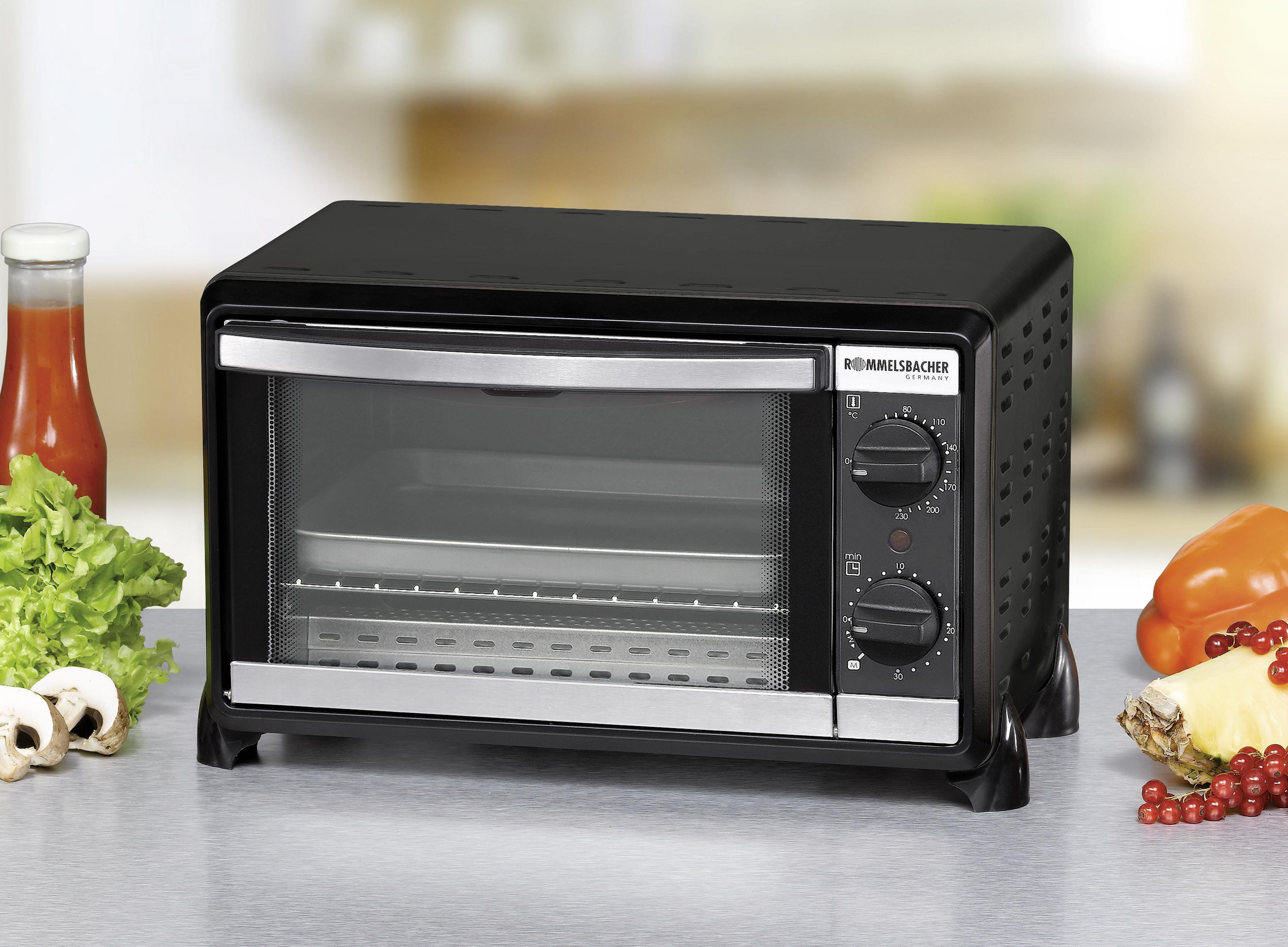 Schwarz-silberner Toaster-Ofen mit Essen und Gemüse.