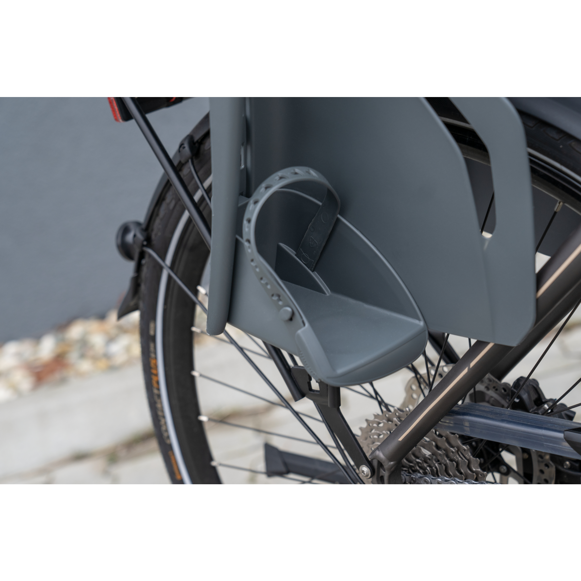 Ein Fahrrad mit einem Kindersitz. Der Sitz ist grau, die Räder sind schwarz.