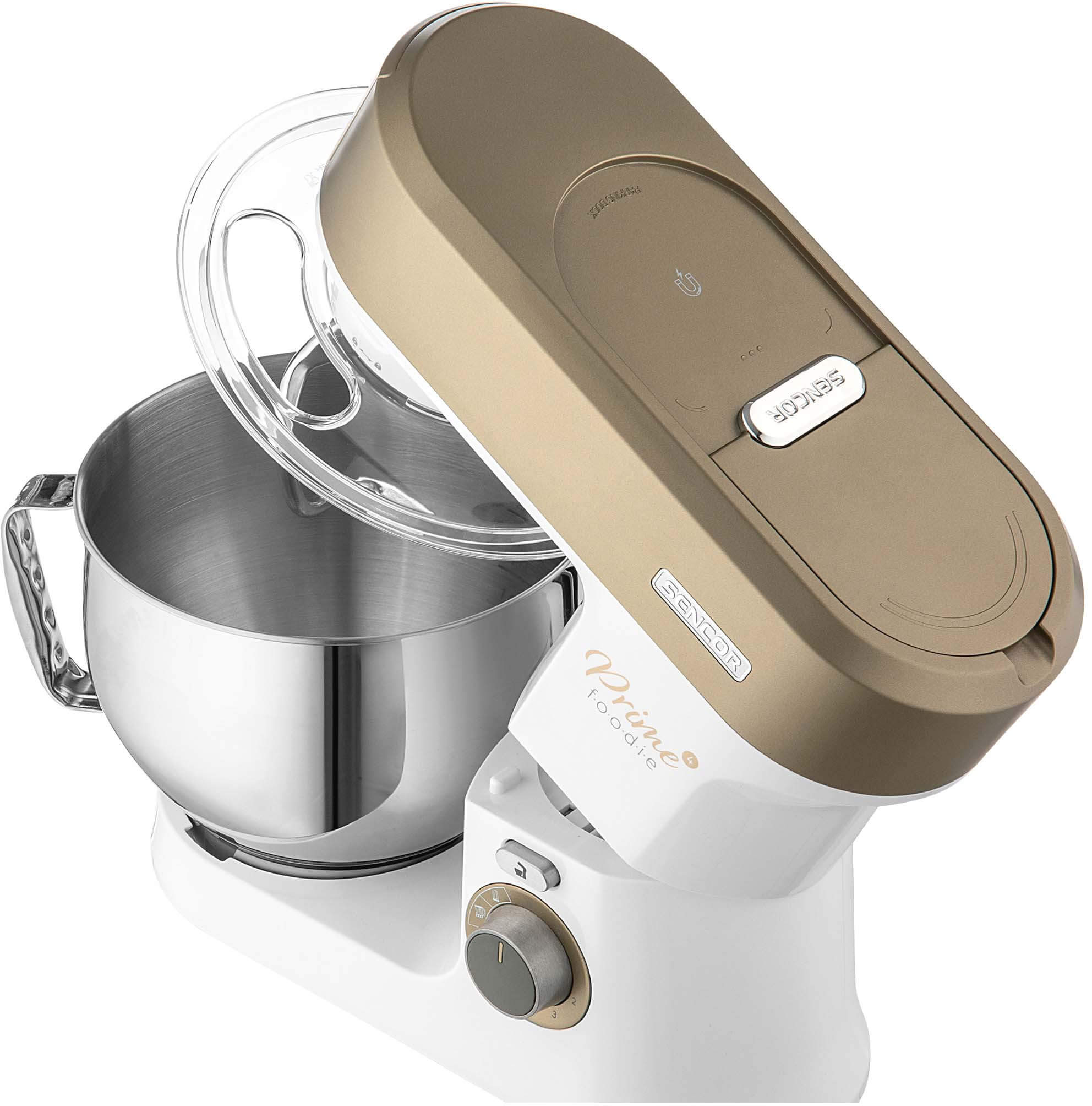 Egy arany-fehér konyhai mixer átlátszó tálfedővel. Be van kapcsolva.