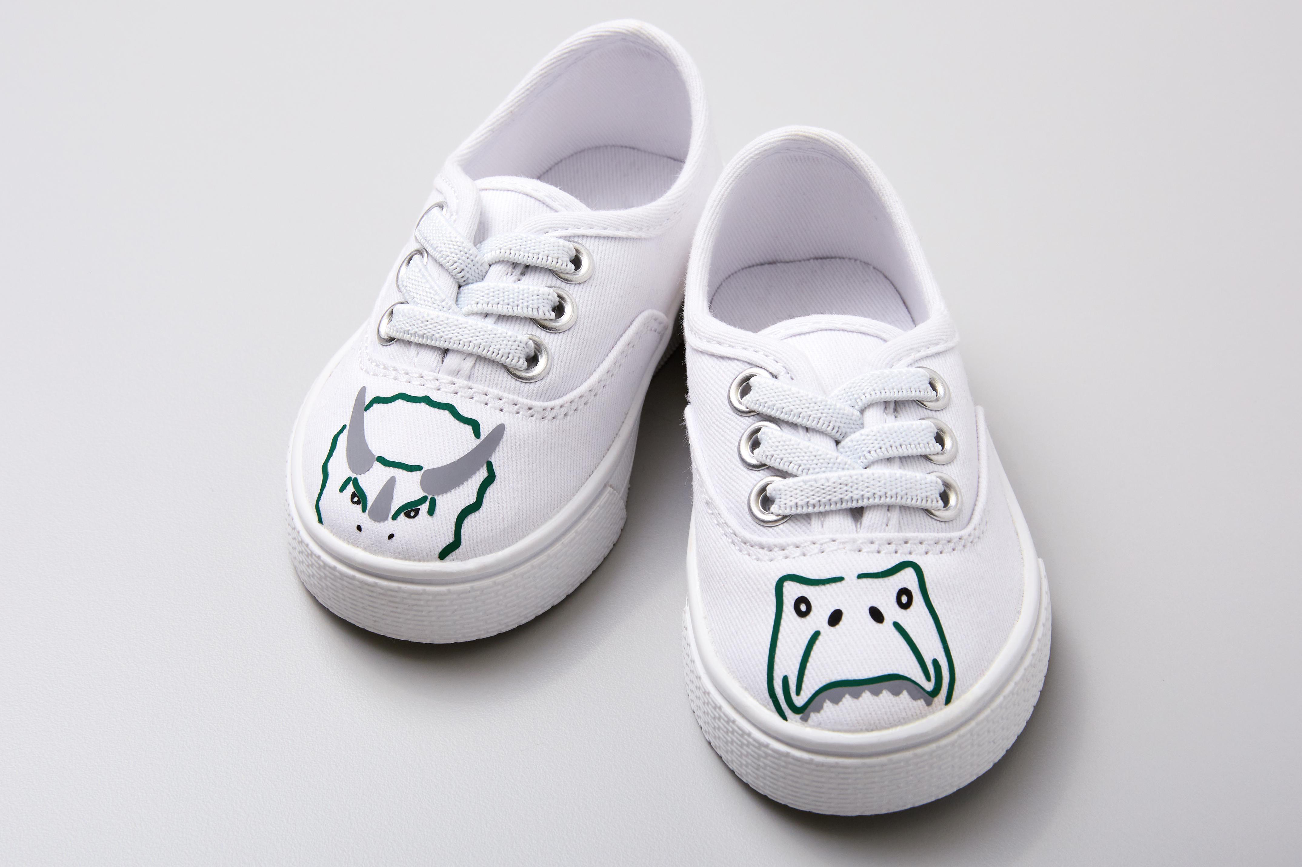 Ein Paar weiße Leinenschuhe mit Cartoonzeichnungen darauf.
