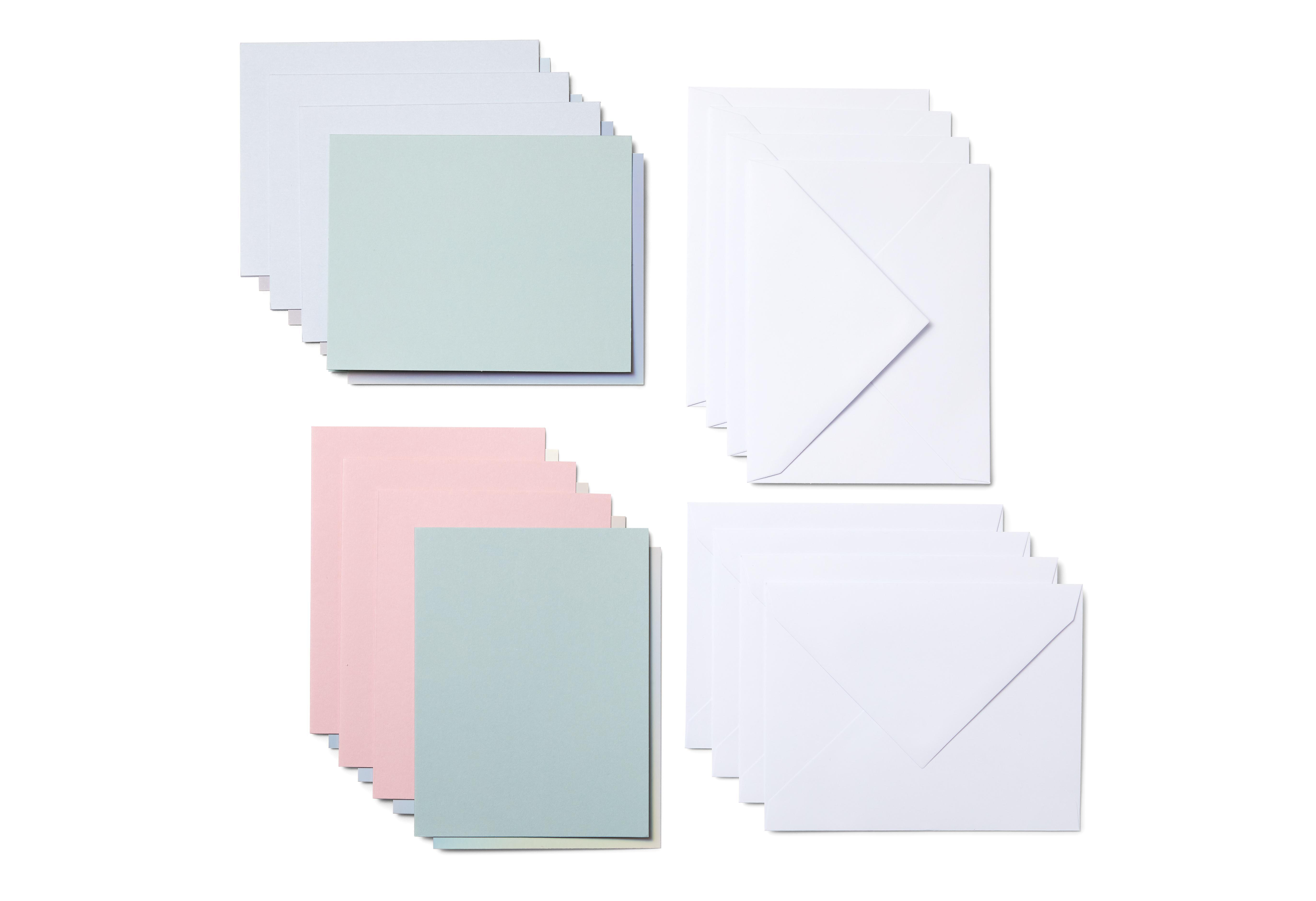 Vier Stapel Papier, jeweils in verschiedenen Pastellfarben, und weiße Umschläge werden auf weißem Hintergrund angezeigt.