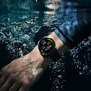 Der Arm einer Person, die eine Smartwatch unter Wasser trägt. Blasen steigen um den Arm auf.