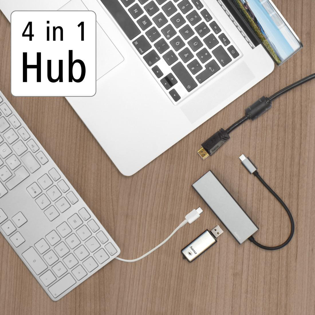 Laptop mit Hub und Zubehör auf einem Holztisch.