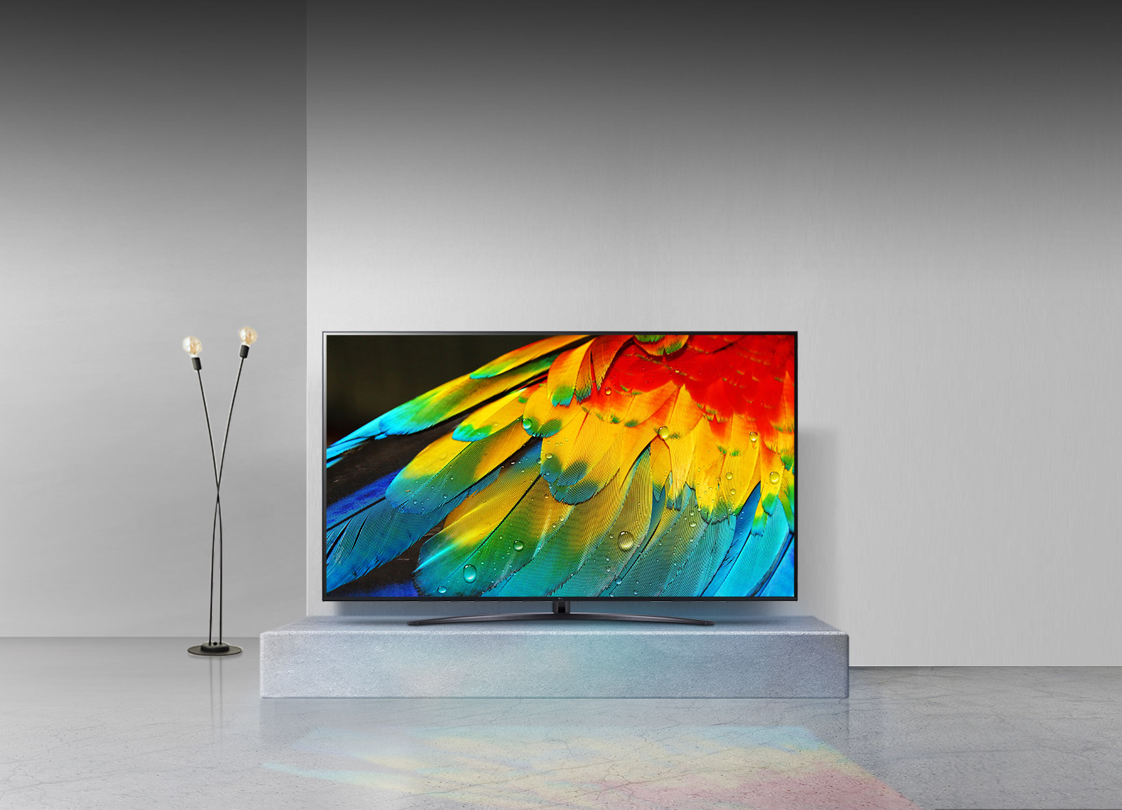 Egy nagy TV színes tollakat jelenít meg egy állványon egy lámpával.