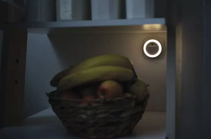 Hűtőszekrény belseje gyümölccsel és fénnyel.
