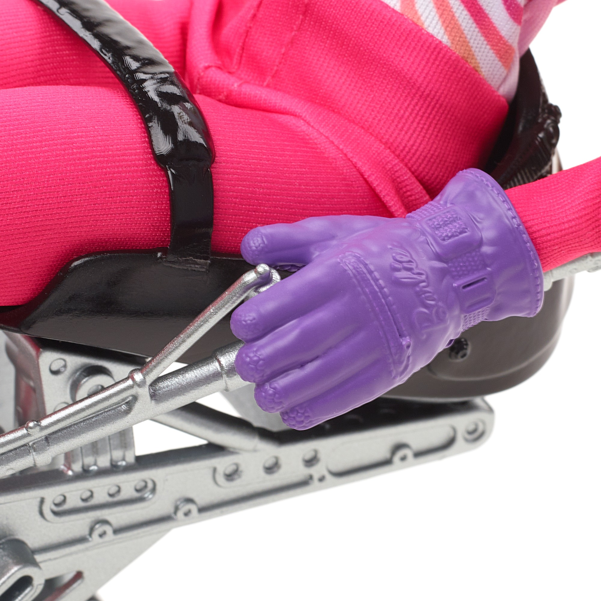 Nahaufnahme eines lilafarbenen Barbie-Handschuhs, der einen silbernen Skiliftgriff hält, auf einem rosa Skianzug.