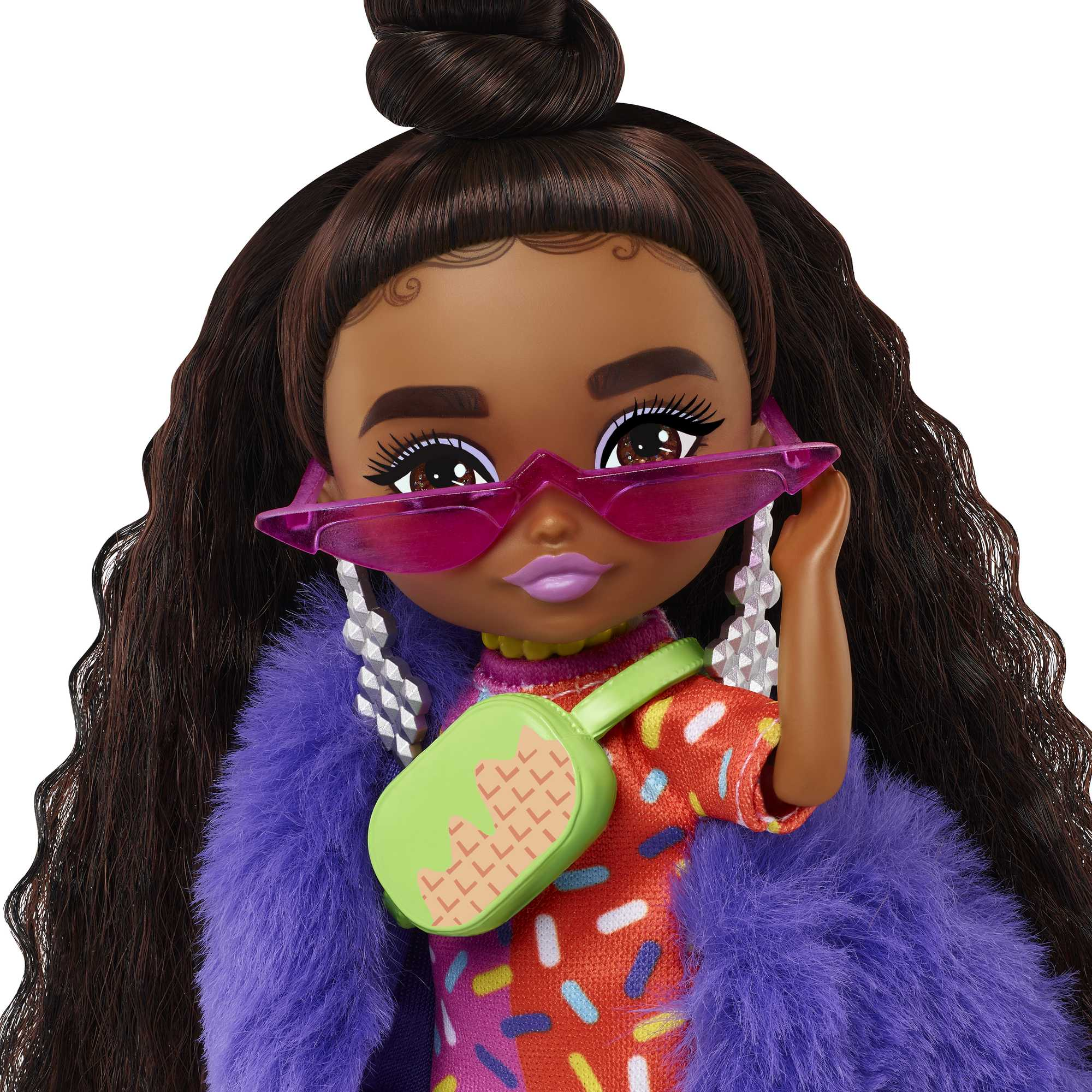 Nahaufnahme einer Puppe mit Sonnenbrille und lila Pelzmantel mit grüner Tasche.