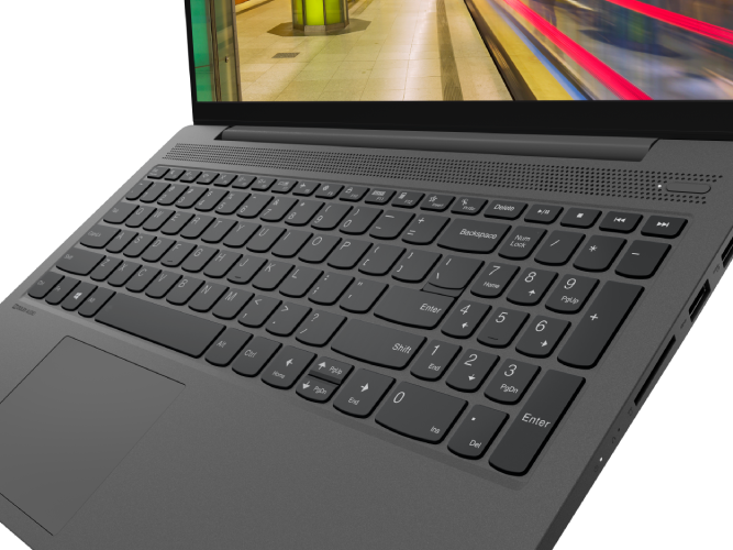 Un teclado de portátil con una visión borrosa del fondo a través de la pantalla. El portátil es gris.