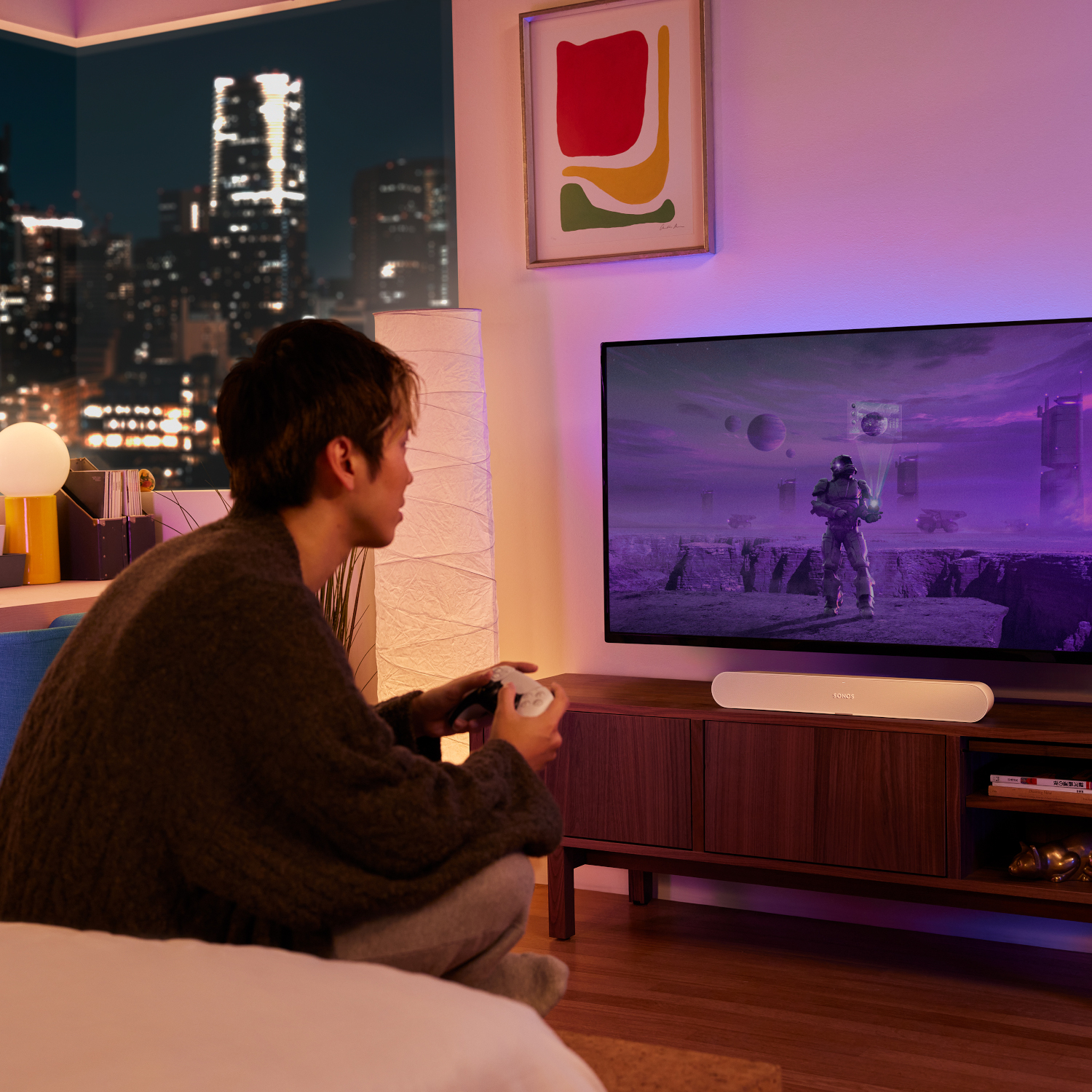 Man speelt spel op tv met een witte soundbar.