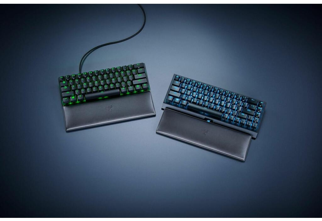Zwei Tastaturen mit Handgelenkauflagen. Schwarze Tasten, grüne und blaue Lichter.