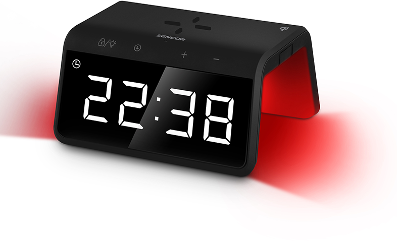 Fekete digitális ébresztőóra piros fénnyel. '22:38'-at mutat és beállító gombokkal rendelkezik. Az órán van egy töltőpad.