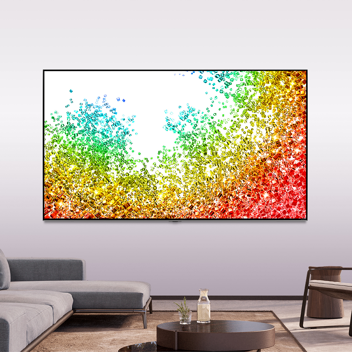 Pantalla de TV grande mostrando arte abstracto colorido. Sofá y pared grises. Salón moderno.