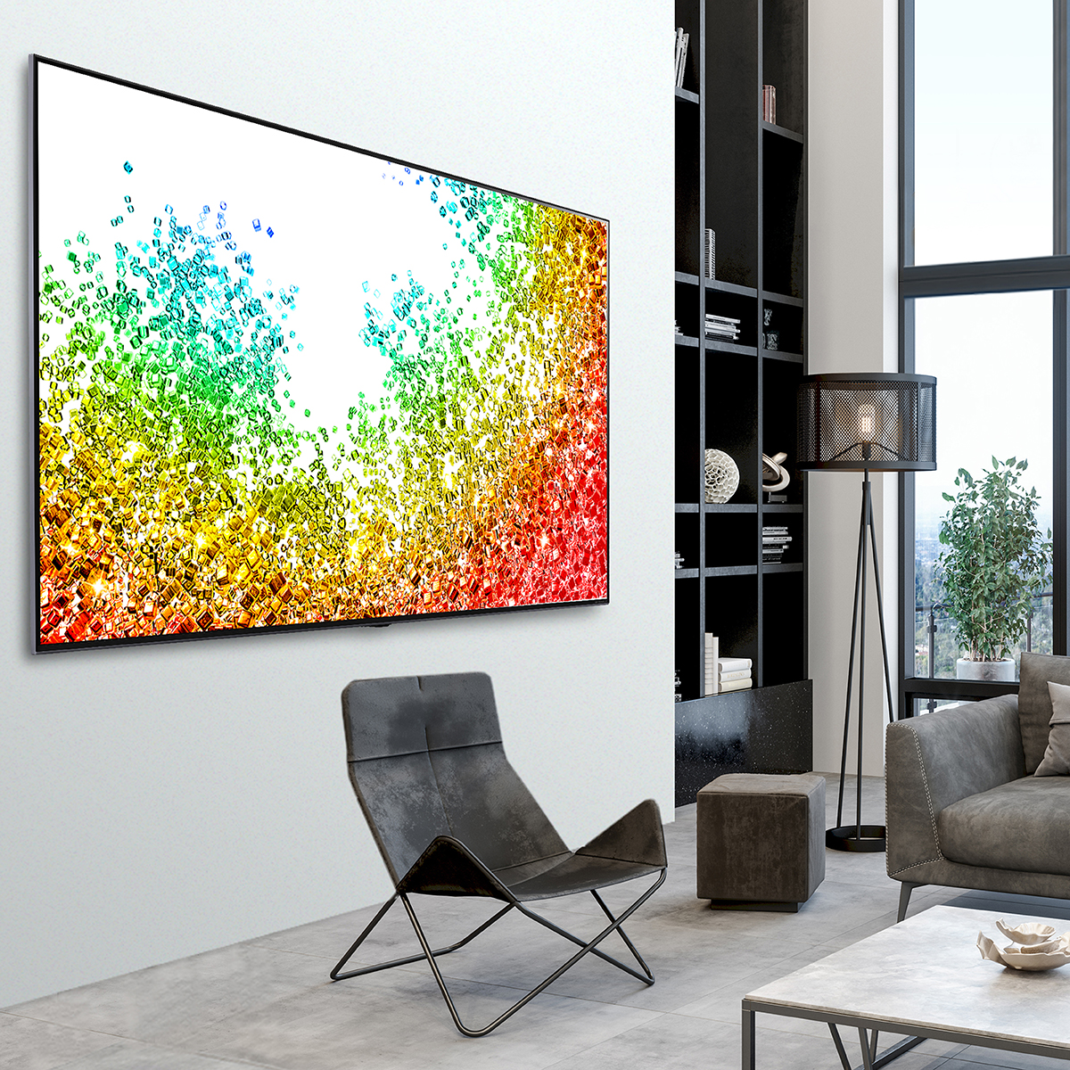 Una gran pantalla de TV que muestra una imagen colorida está montada en una pared blanca en un salón moderno.