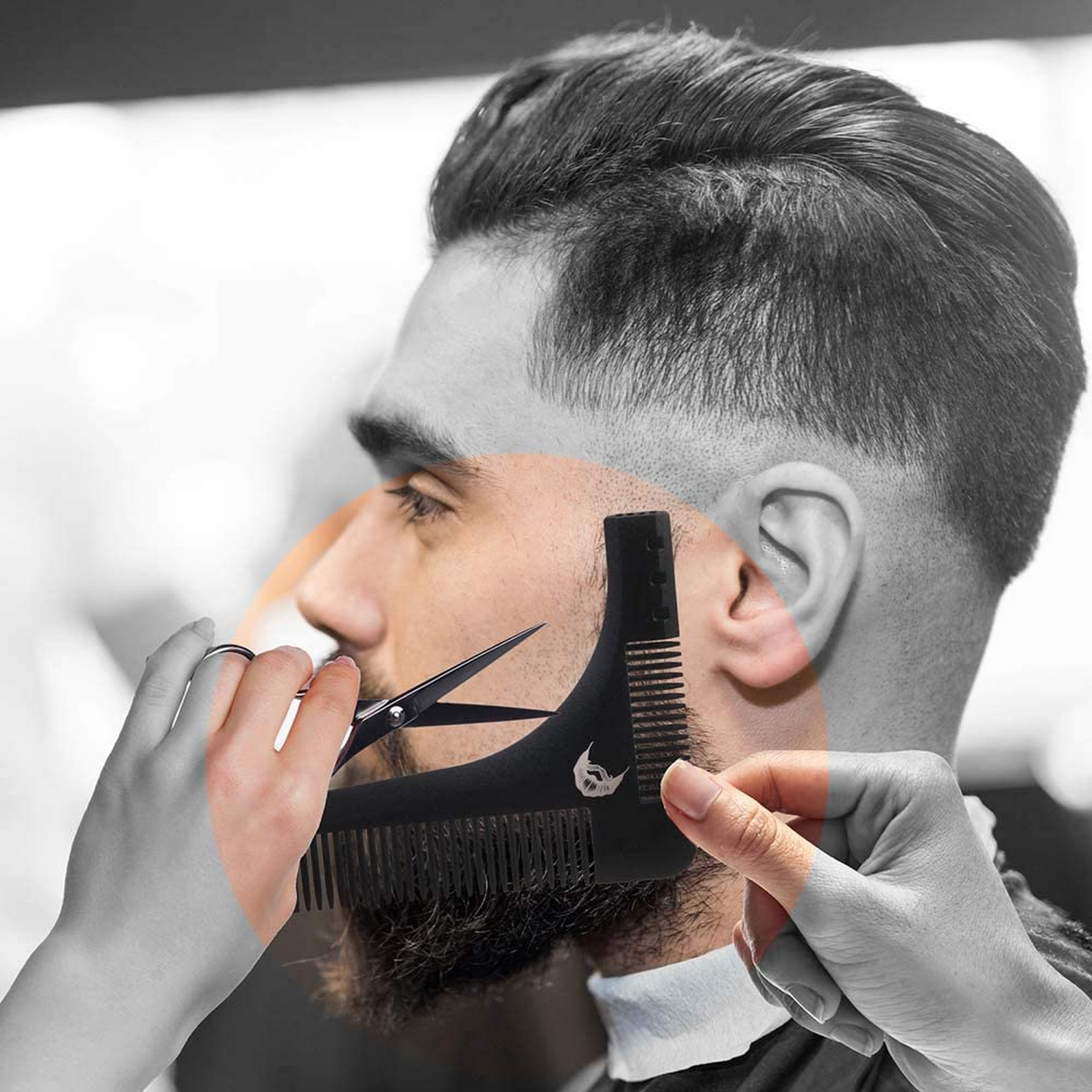 Hombre usando un peine y tijeras. Peine y tijeras son negros. Hombre tiene barba y pelo corto.