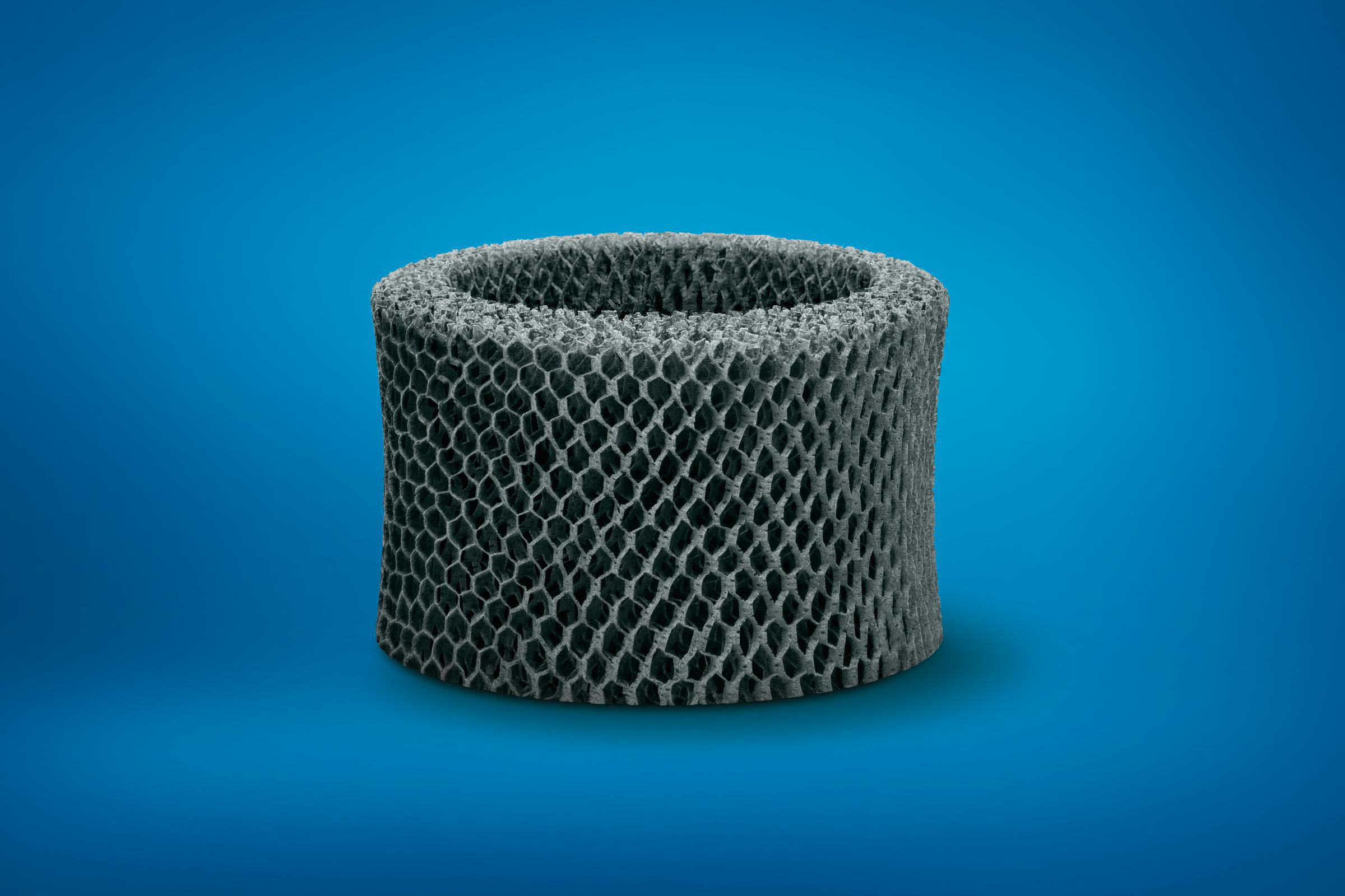Ein zylindrisches Objekt mit Wabenstruktur auf blauem Hintergrund, das einem Filter ähnelt.