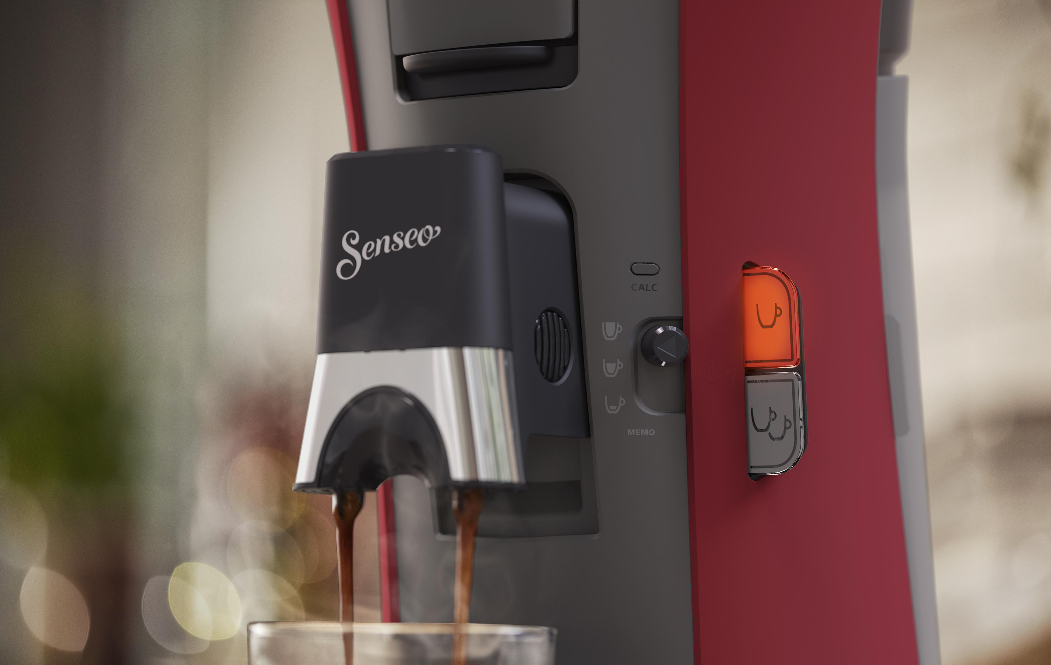 Kaffeemaschine mit Kaffee, der in ein Glas fließt.