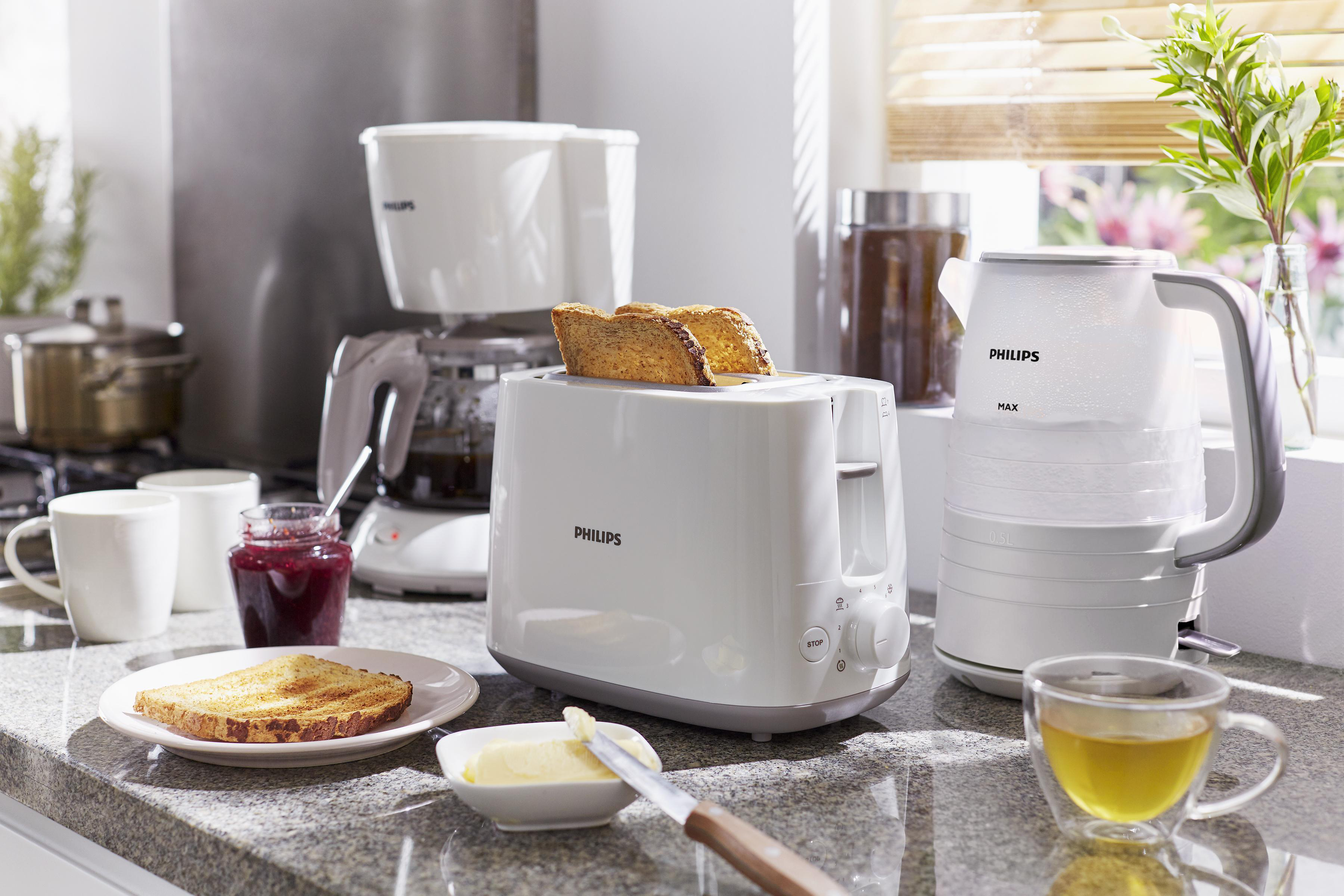 Eine Küchenszene mit Toaster, Kaffeemaschine, Wasserkocher und Frühstücksartikeln.
