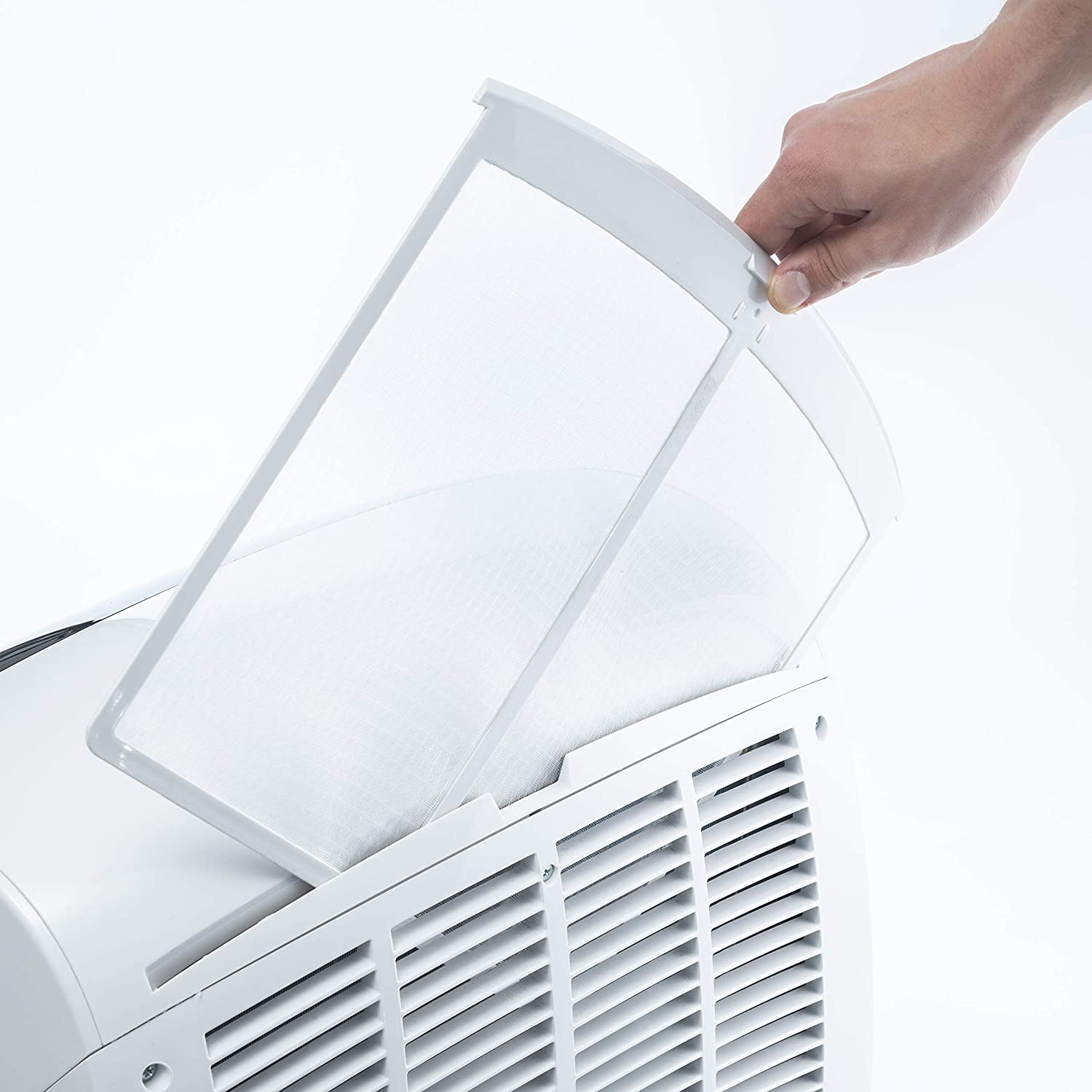Una mano quitando un filtro de aire blanco de un electrodoméstico blanco.