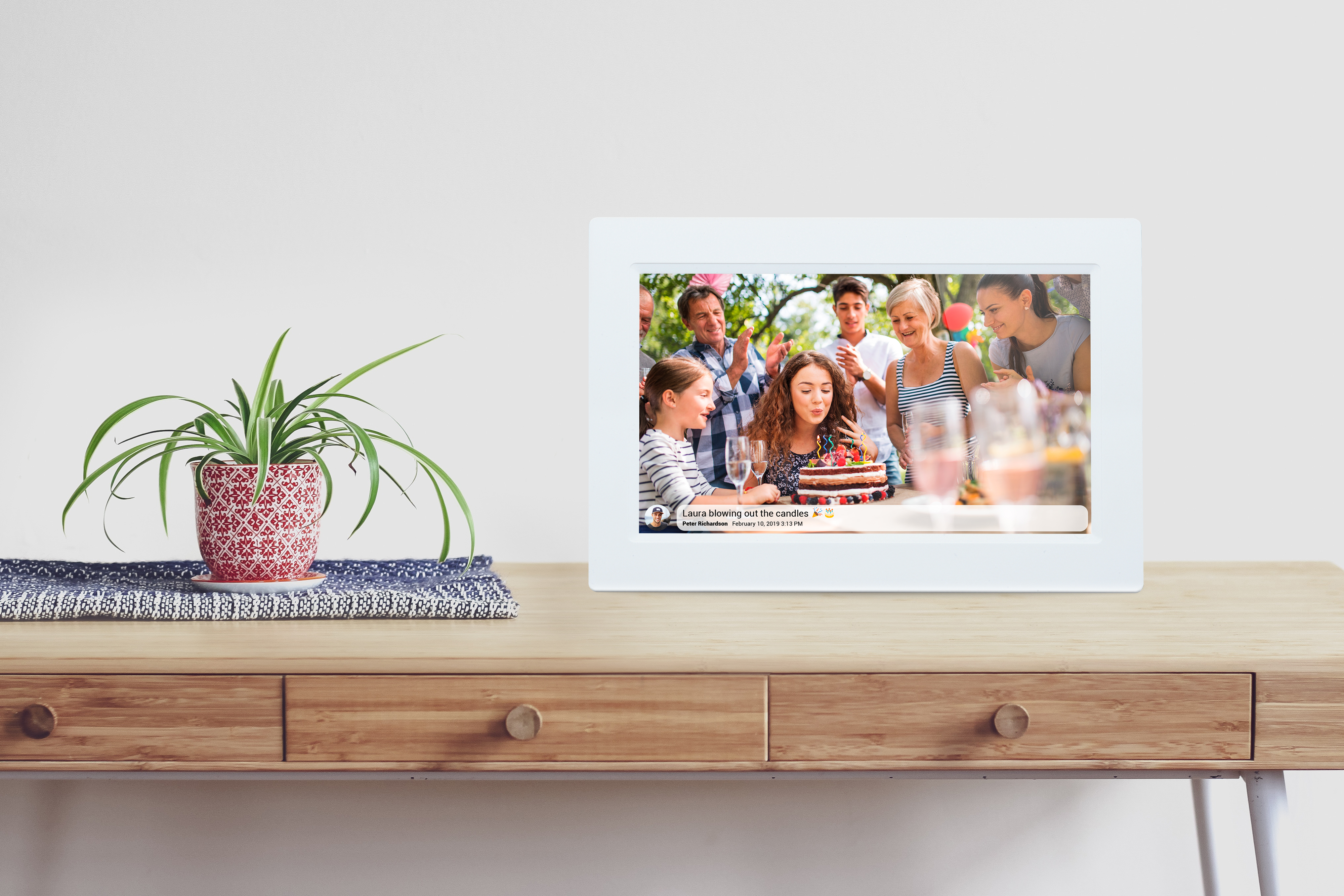 Cadre photo sur un bureau, affichant une photo d'anniversaire. Personnes en arrière-plan.
