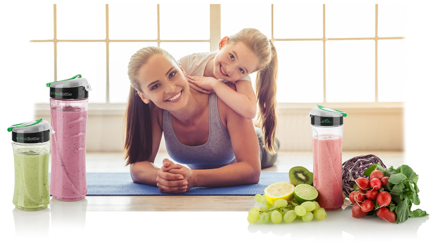 Egy nő és egy gyermek mosolyog egy kék szőnyegen, smoothie-kkal és gyümölcsökkel az oldalán. Természetes fény.
