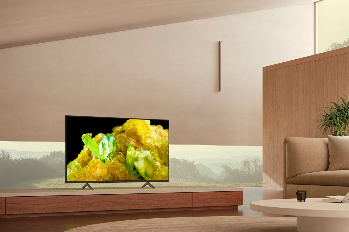 Ein modernes Wohnzimmer mit einem Fernseher, der eine Nahaufnahme von gelben Kristallen zeigt.