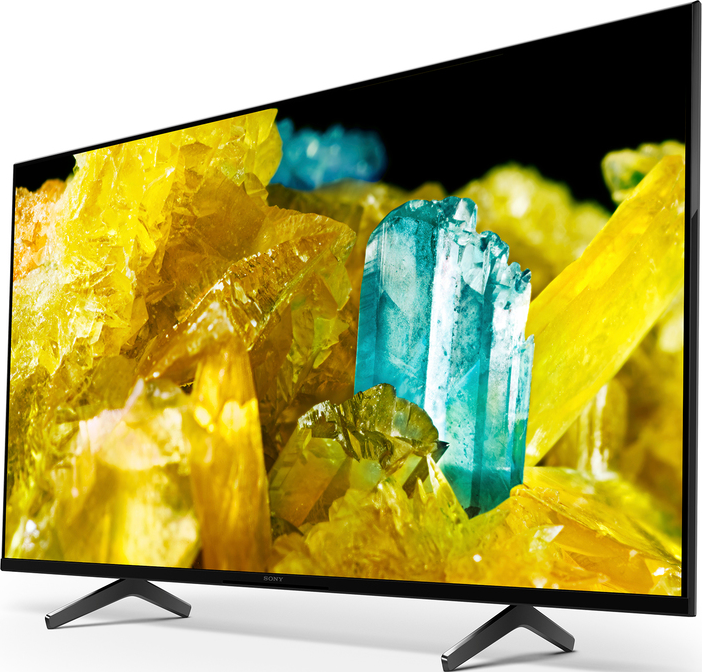 Ein großer schwarzer Fernseher mit farbenfrohen abstrakten Bildern auf weißem Untergrund.