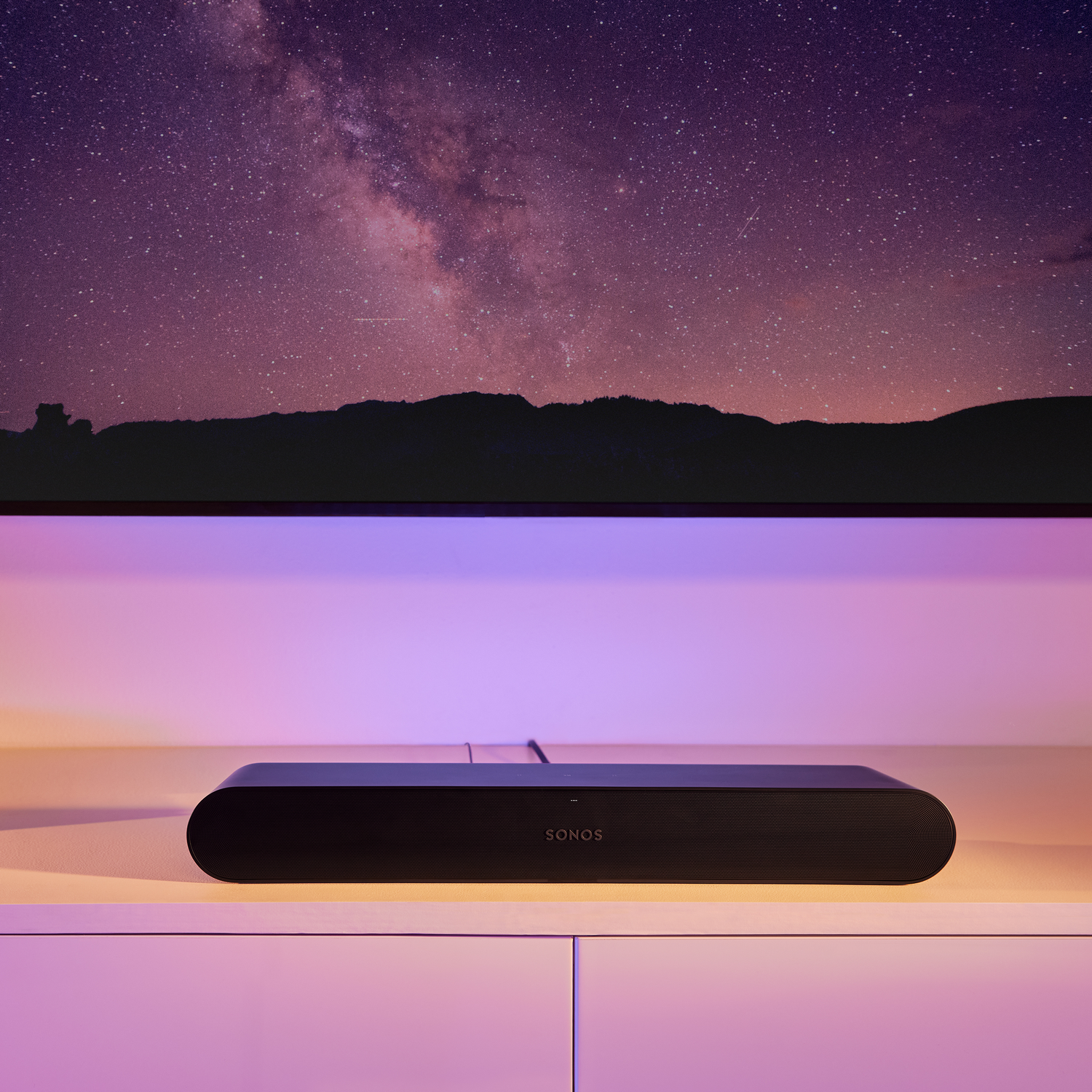 Barra de sonido negra debajo de un televisor que muestra una noche estrellada.