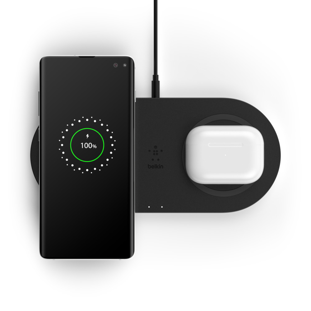 Siyah kablosuz şarj cihazı, %100 şarj olan bir telefon ve beyaz kulaklıklar.