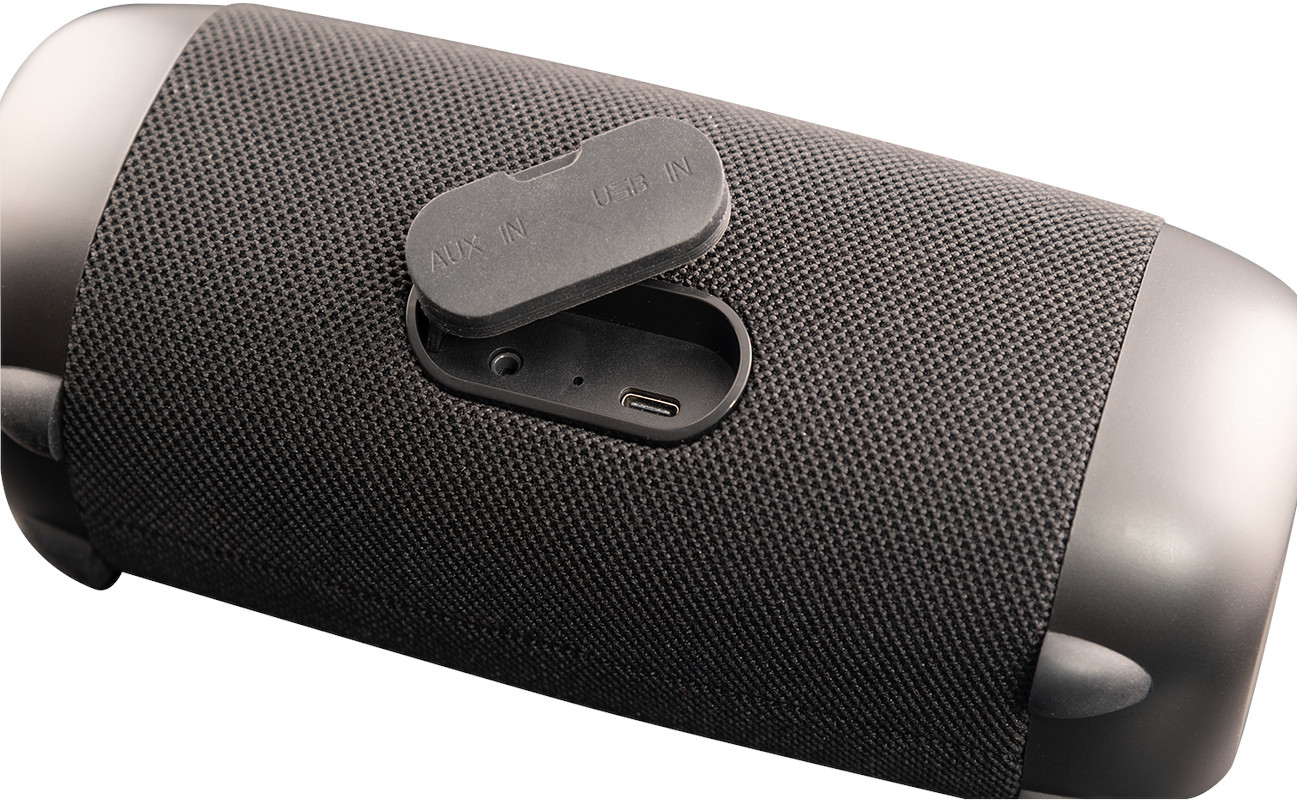Black portable speaker, with ports for AUX and USB, and a USB-C port. Fabric texture.