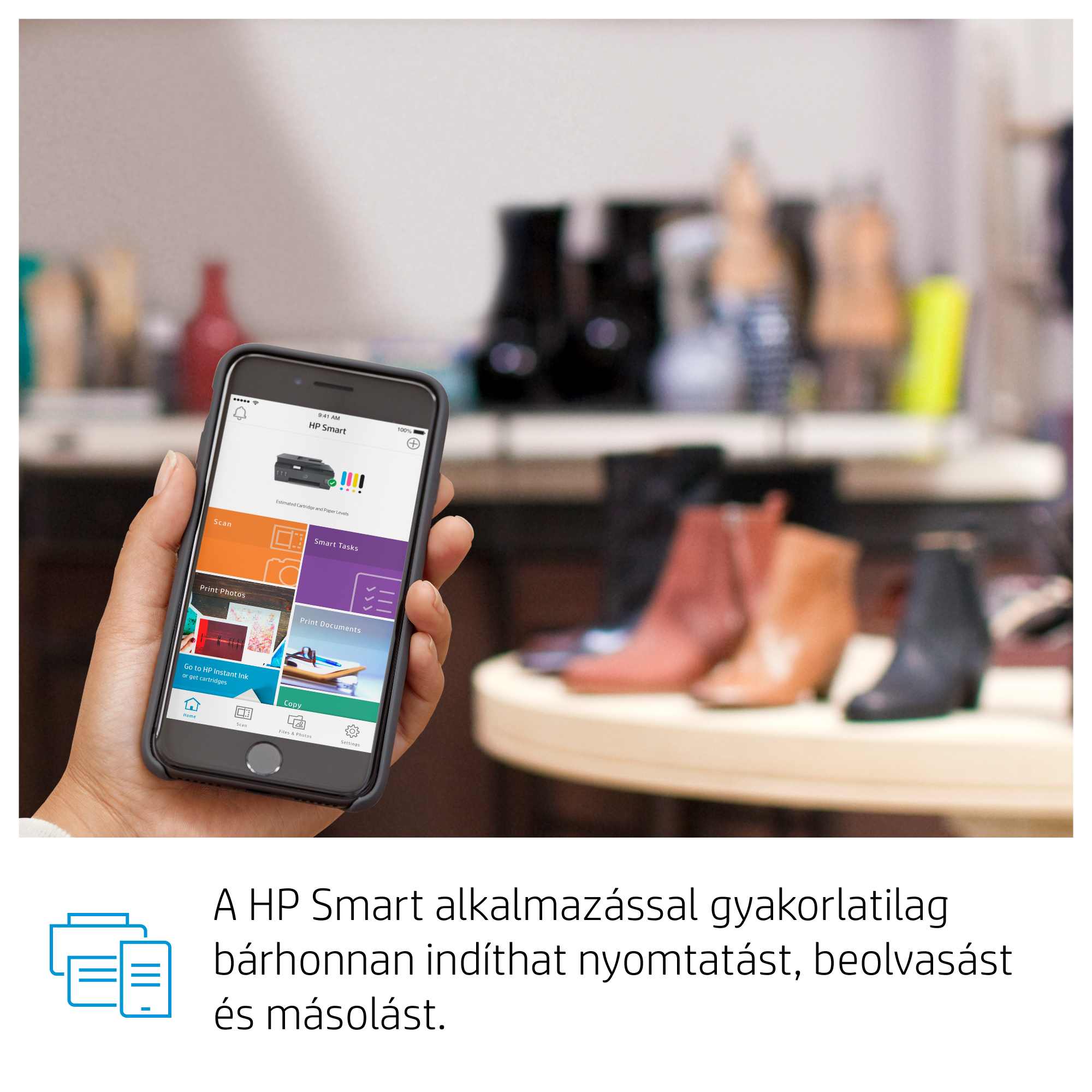 Kéz okostelefont tart, nyomtató app felülettel, cipők a háttérben.