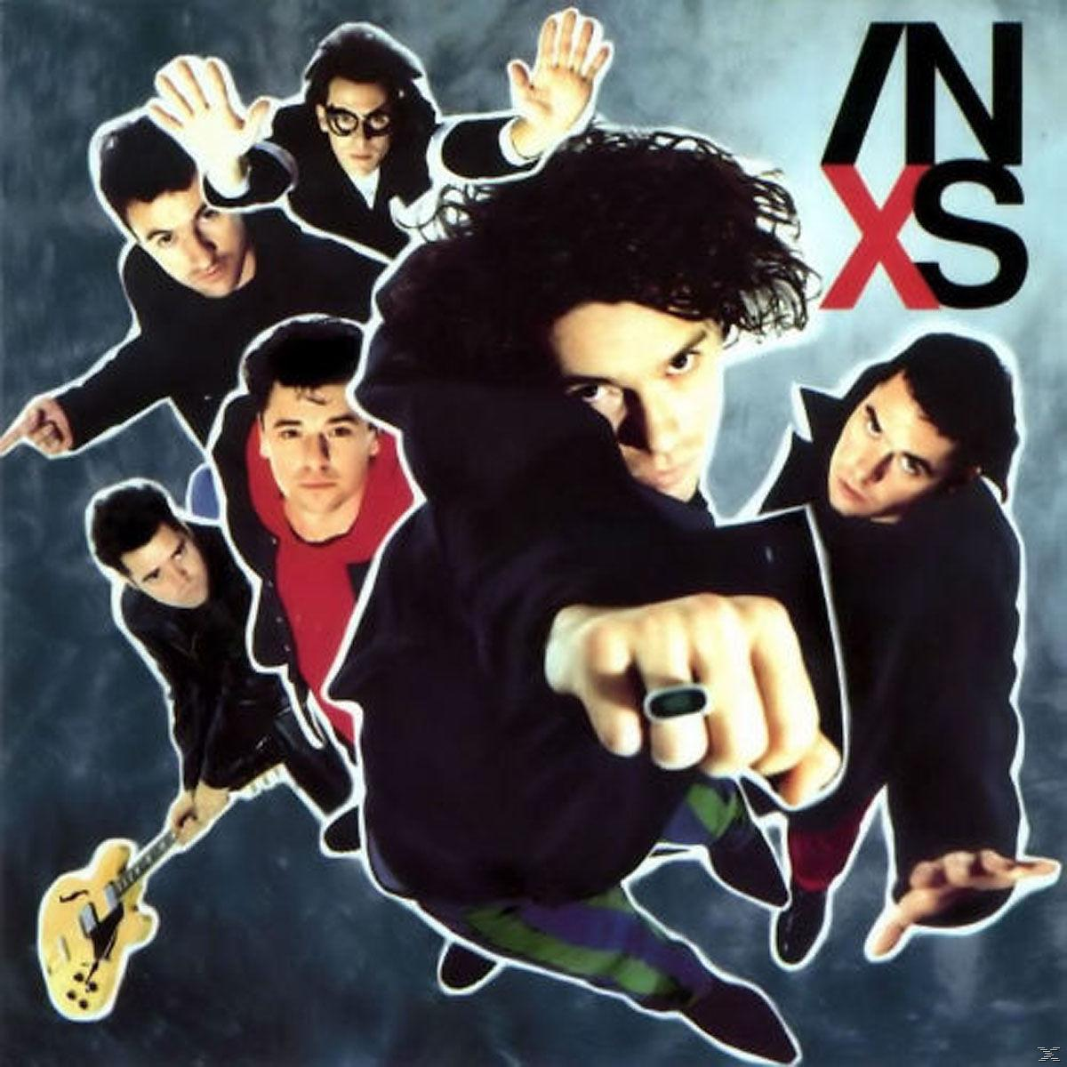 Az INXS együttes tagjai pózolnak. Az egyik mutogat, mások gesztikulálnak. Egy gitáros gitárt tart. A zenekar logója a jobb felső sarokban.