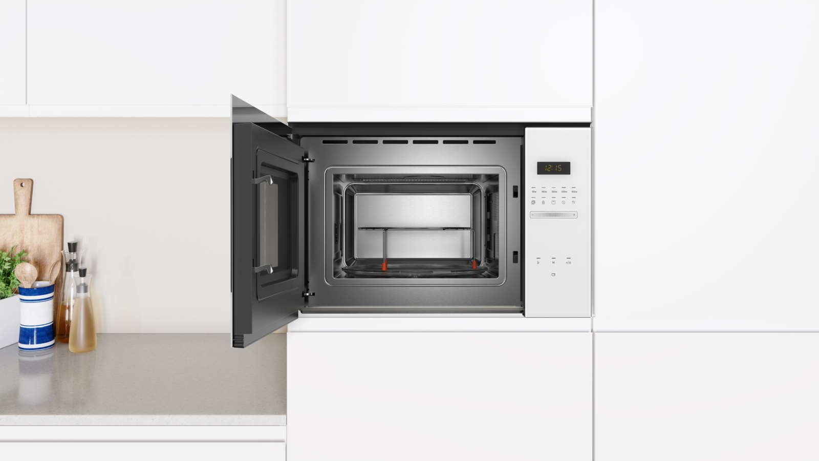 Horno microondas integrado en un armario de cocina blanco, puerta abierta.
