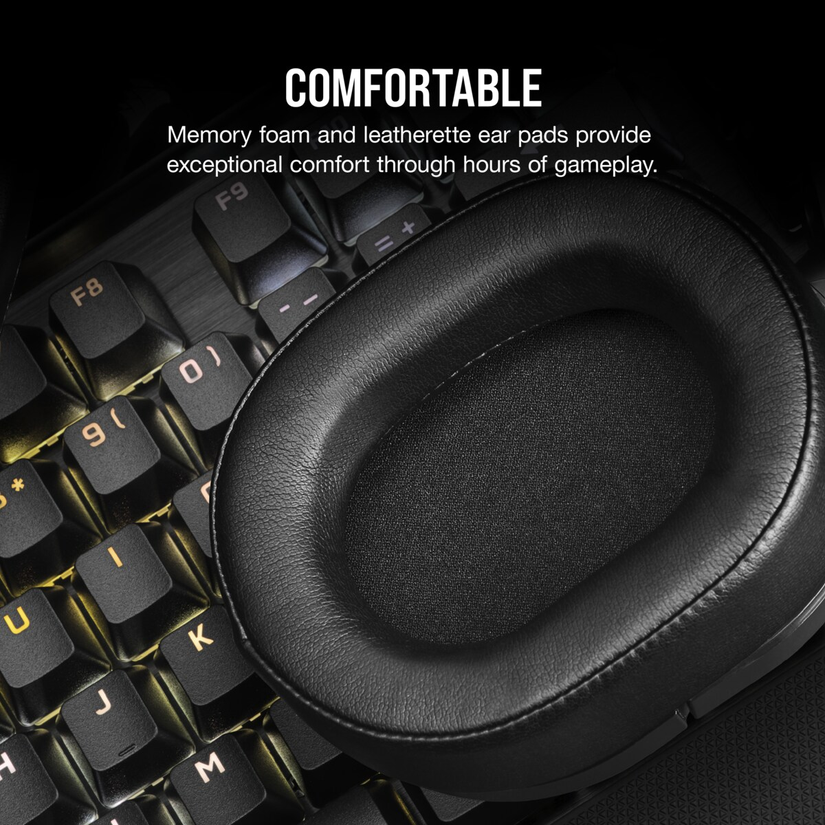 Écouteur de casque de jeu noir sur un clavier éclairé. Le casque est en similicuir. Le mot COMFORTABLE est en haut.